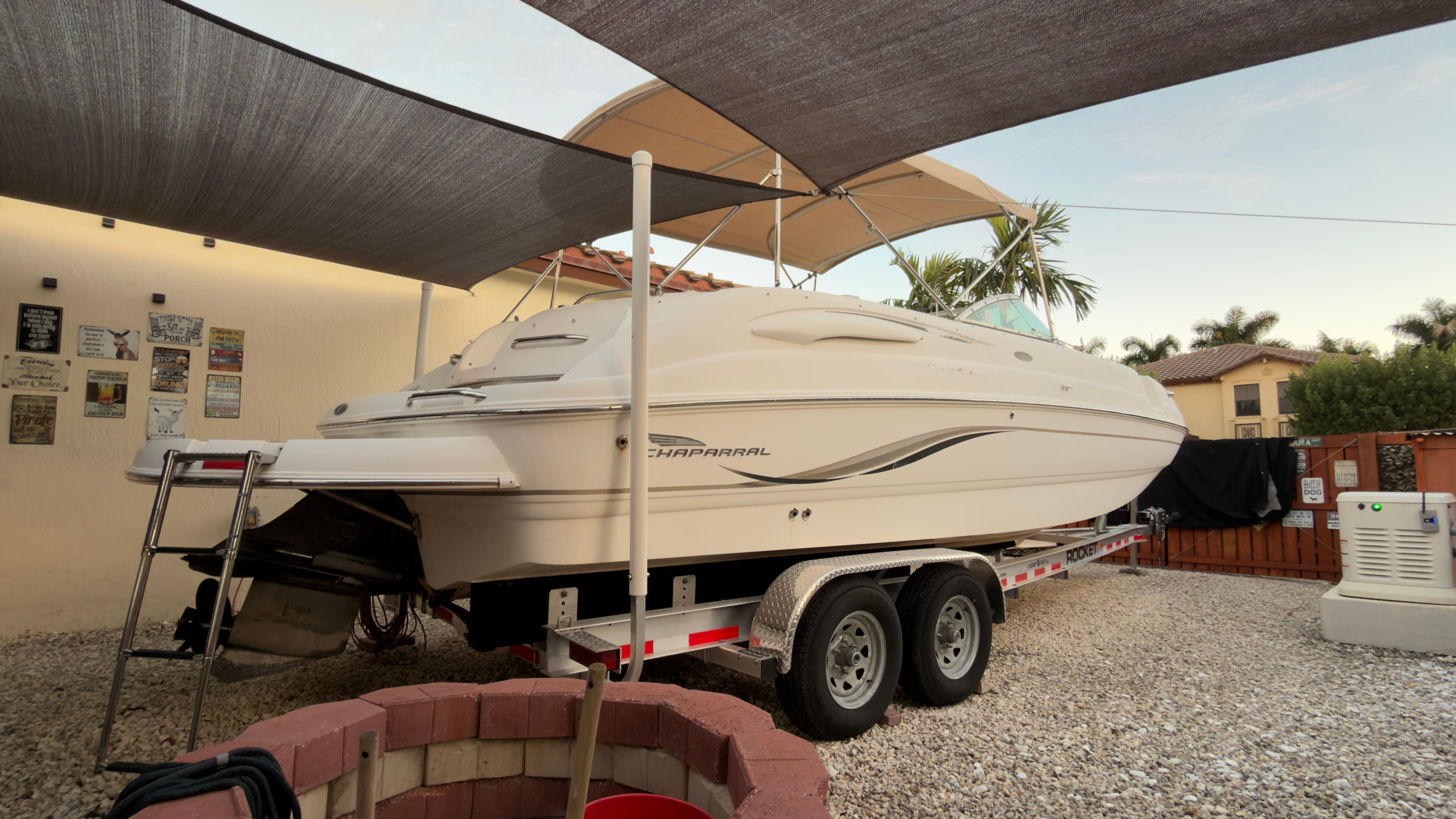 2003 Chaparral 263 Sunesta Deckboat on trailer in yard.