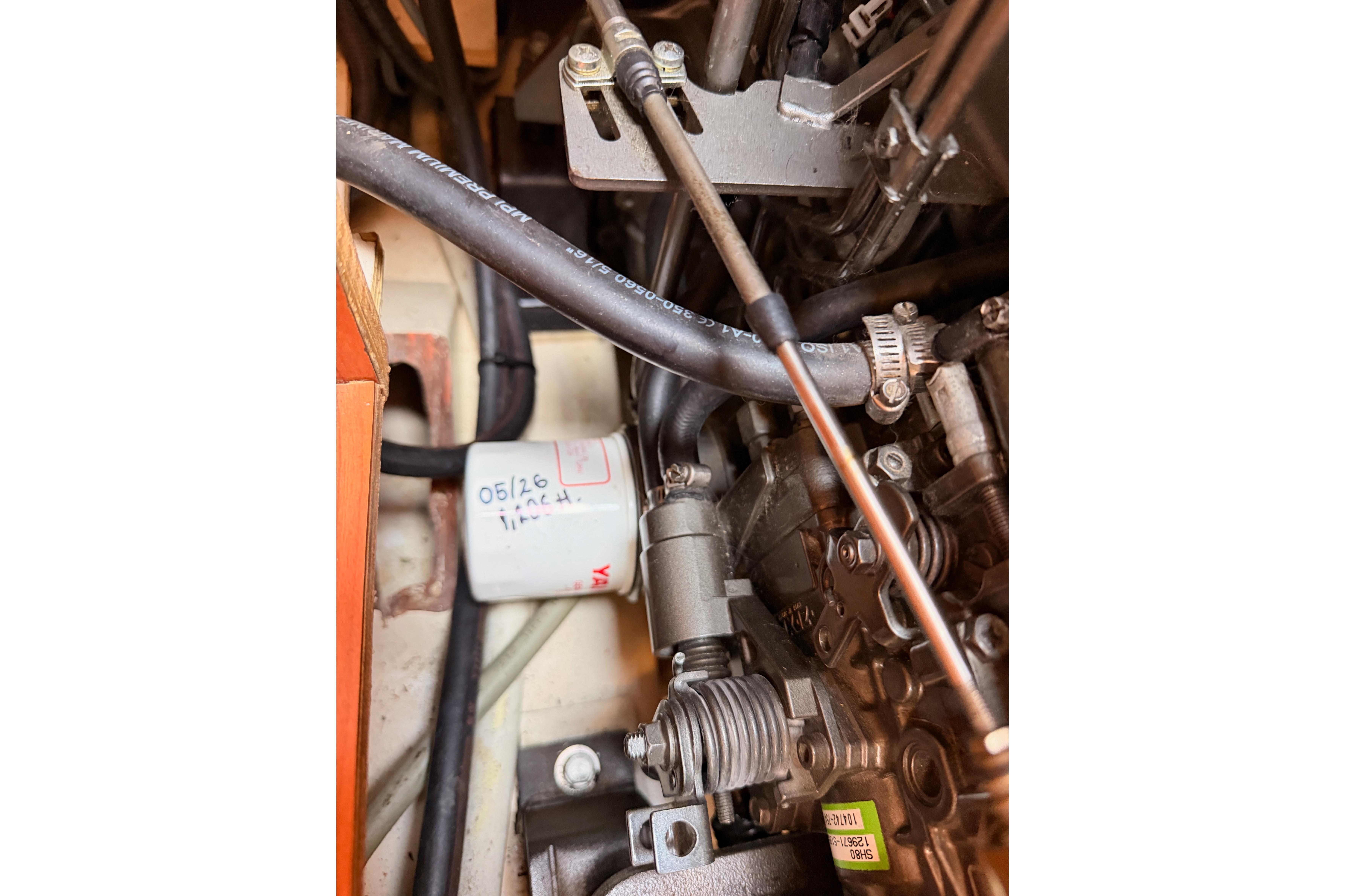 Engine components of a 2008 Hunter 45 Deck Salon sailboat, featuring hoses and mechanical parts.