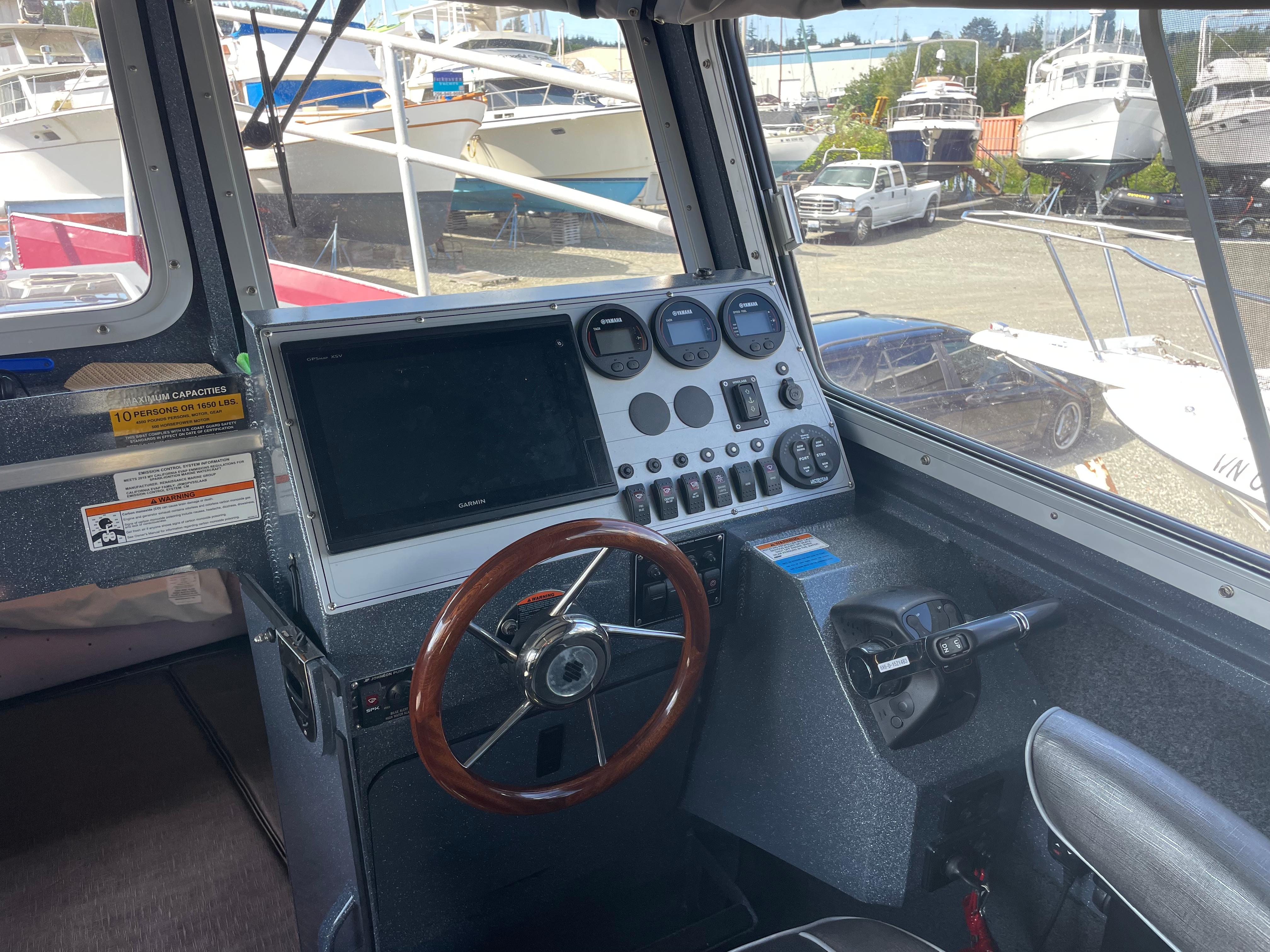 Interior view of 2018 Duckworth 28 Offshore boat cockpit with steering wheel and control panel.
