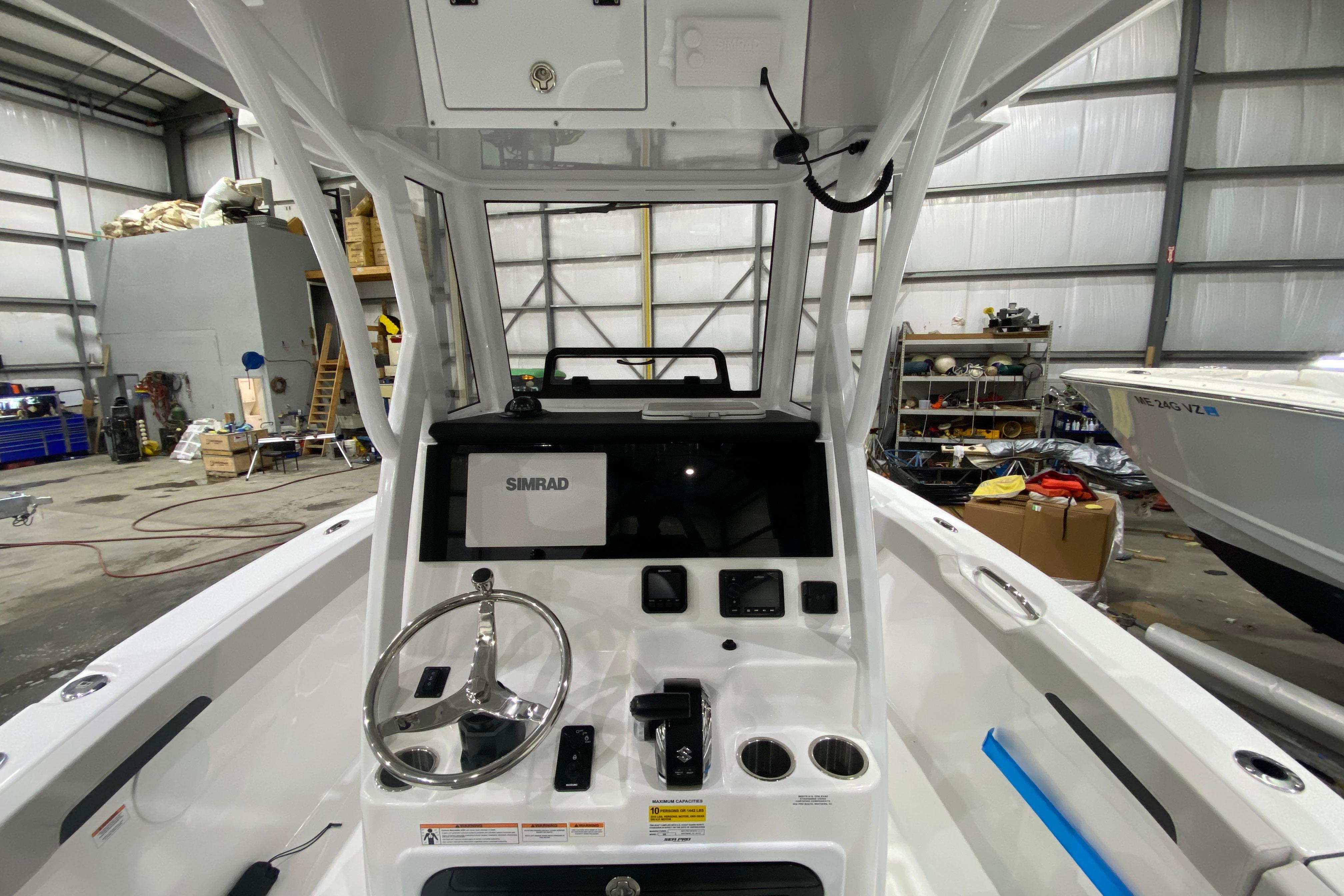 Interior view of 2027 Sea Pro 245FLXR Sandbar boat with steering wheel and Simrad display.