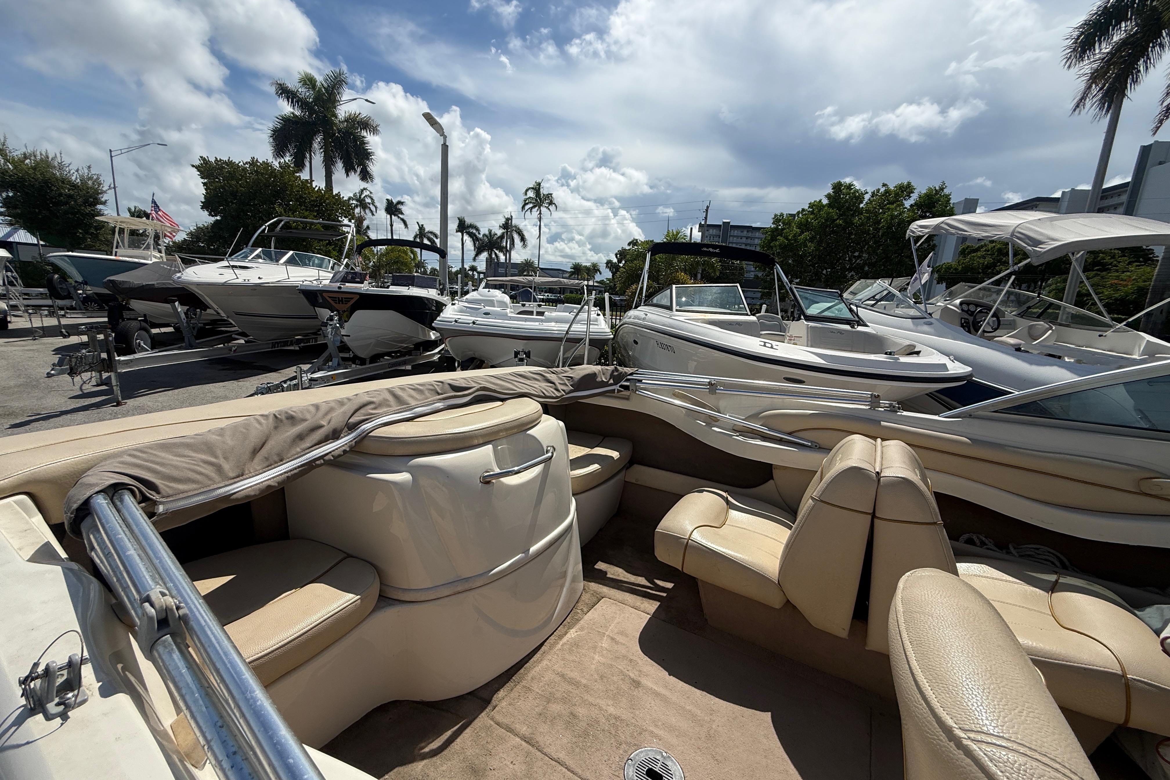 2001 Sea Ray 180 Bow Rider boat in a marina, surrounded by other boats under a cloudy sky.