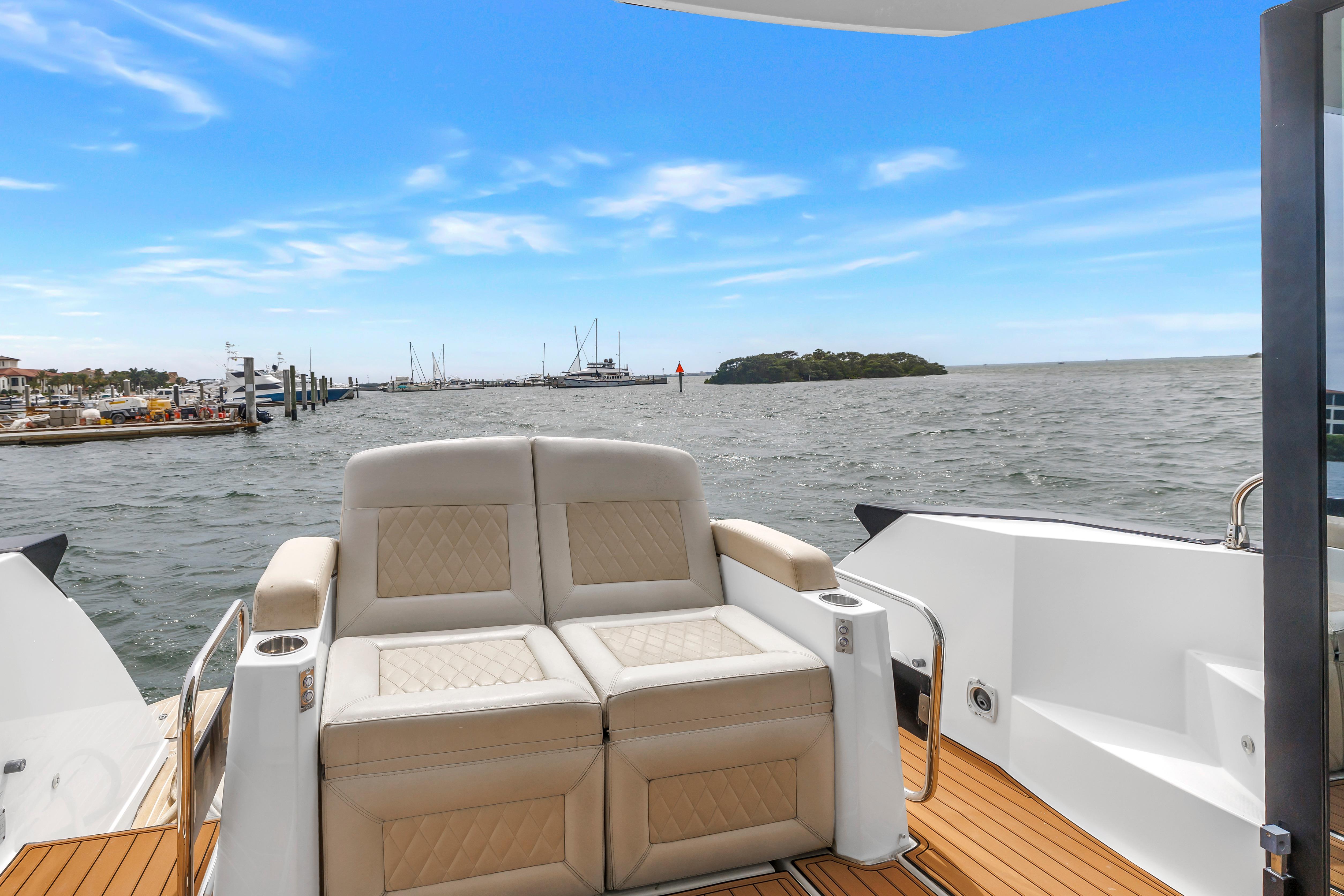 2019 Beneteau Gran Turismo 46 yacht with luxurious seating, ocean view, and clear blue sky.