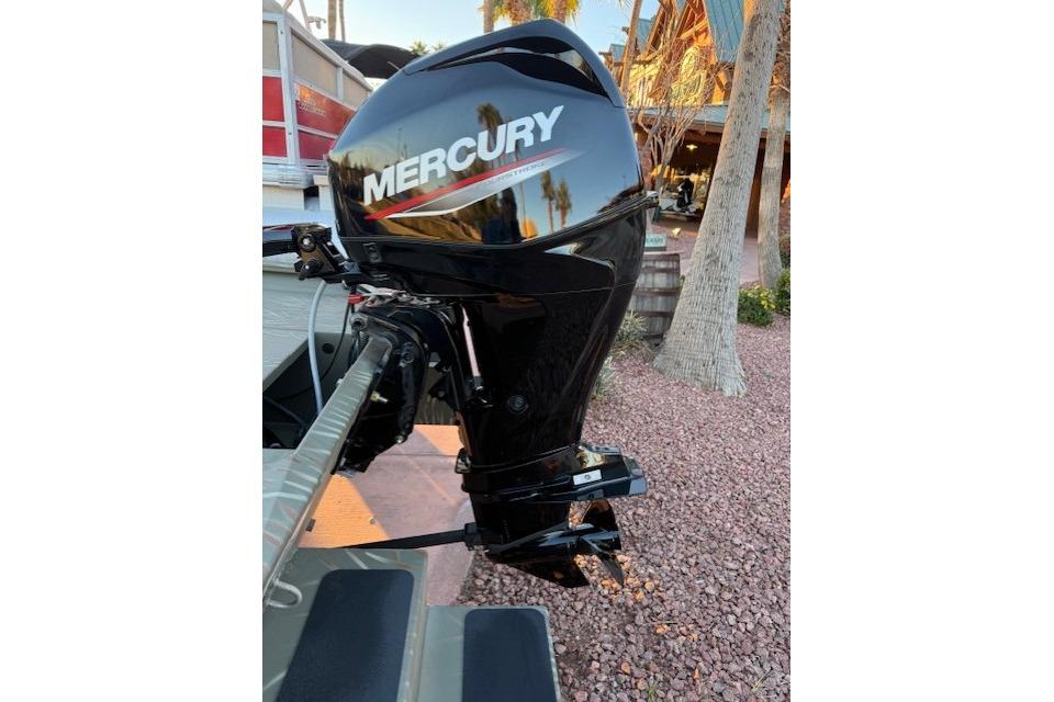 2025 Tracker Grizzly 1654 T Sportsman with Mercury outboard motor in outdoor setting.