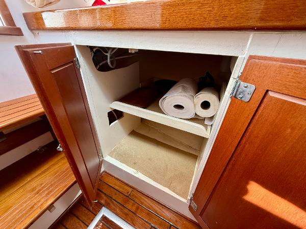 1978 Dyer 29 Trunk Cabin interior with open wooden cabinet and storage shelves.