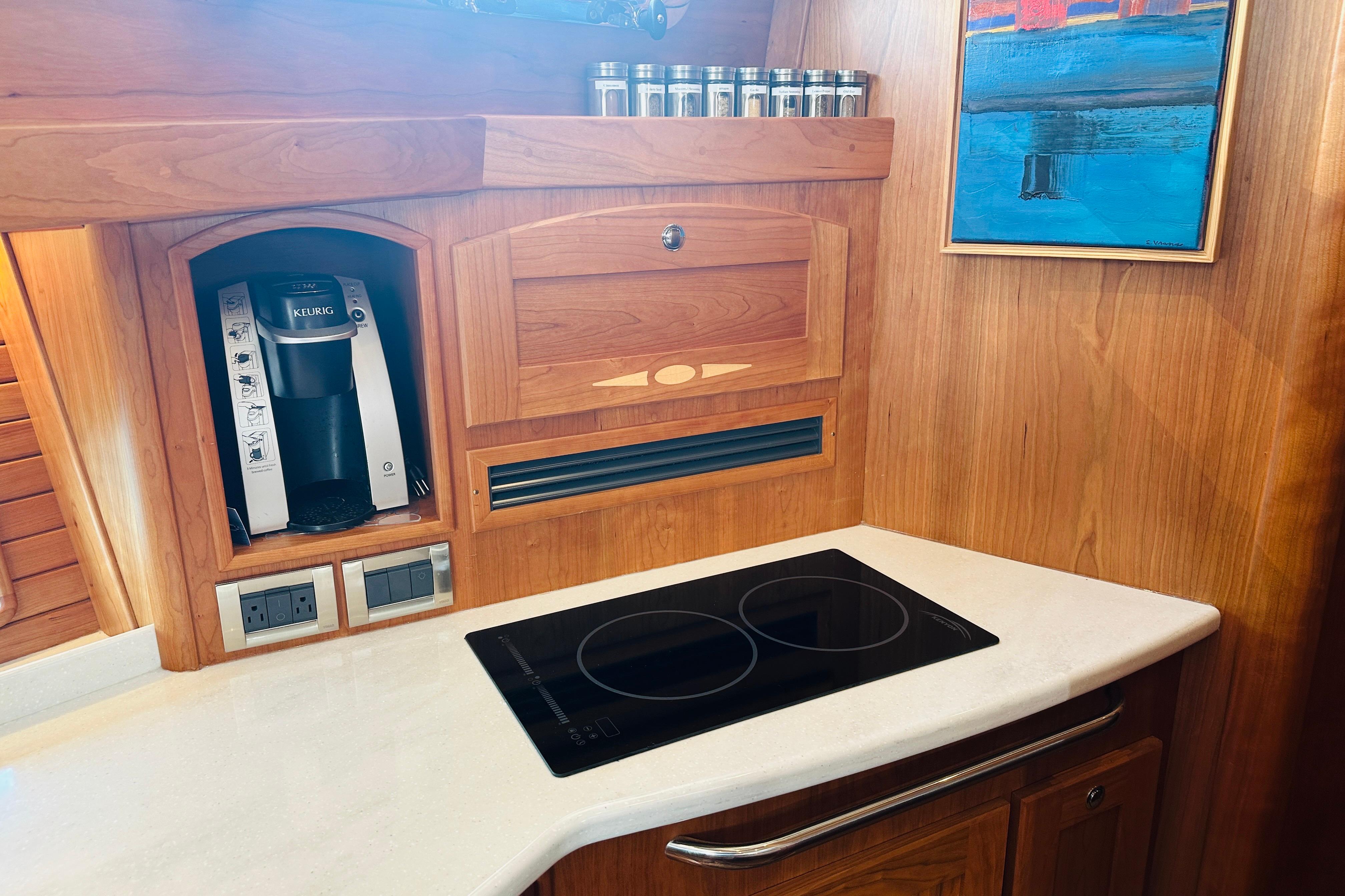 The 2025 Sabre 48 Salon Express kitchen features a cooktop and a coffee maker.