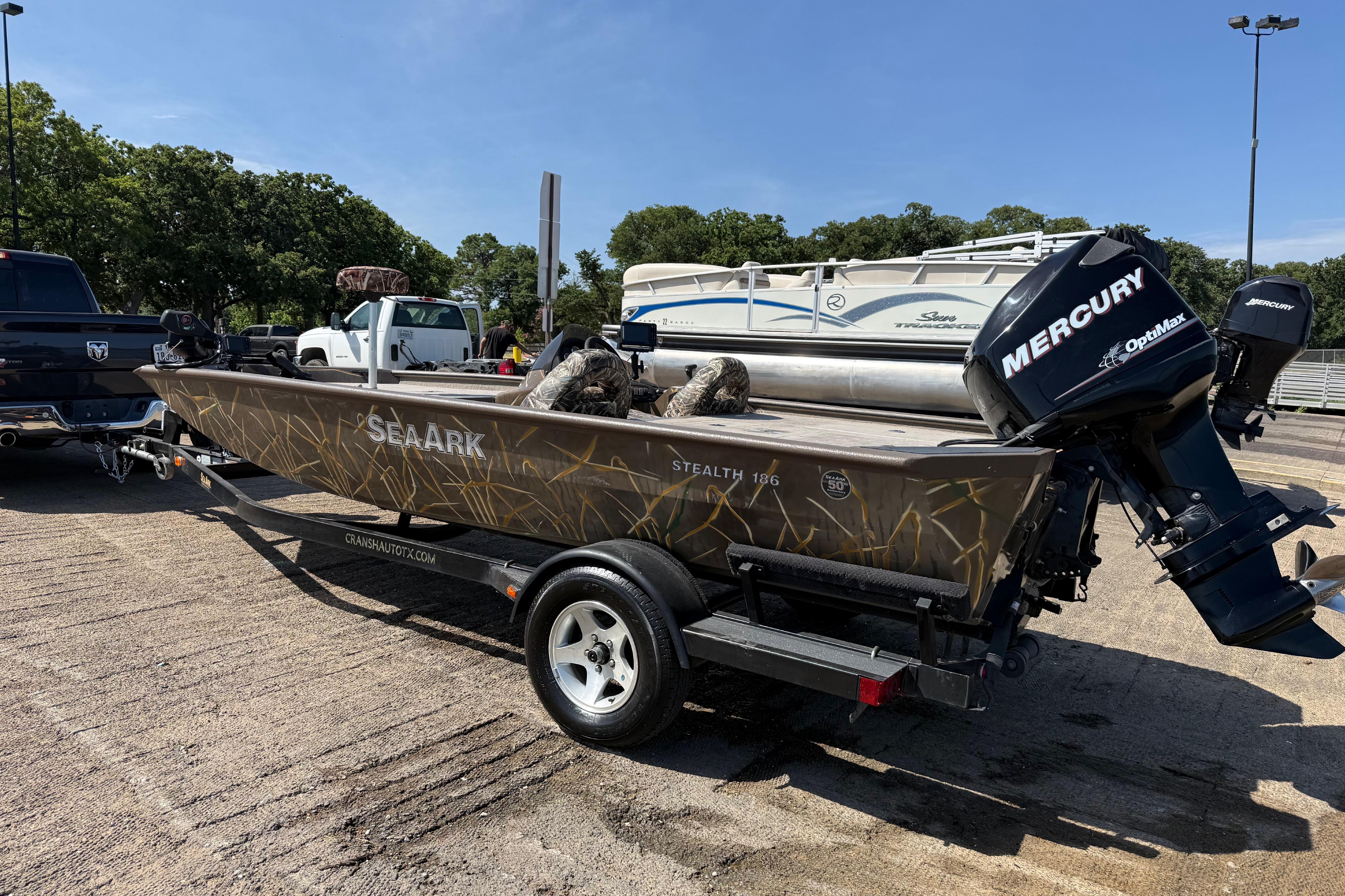 2010 SeaArk Stealth 190 boat with Mercury engine on trailer in parking lot.
