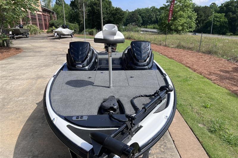 2026 Nitro Z17 boat with dual engines, parked on a concrete path near greenery.