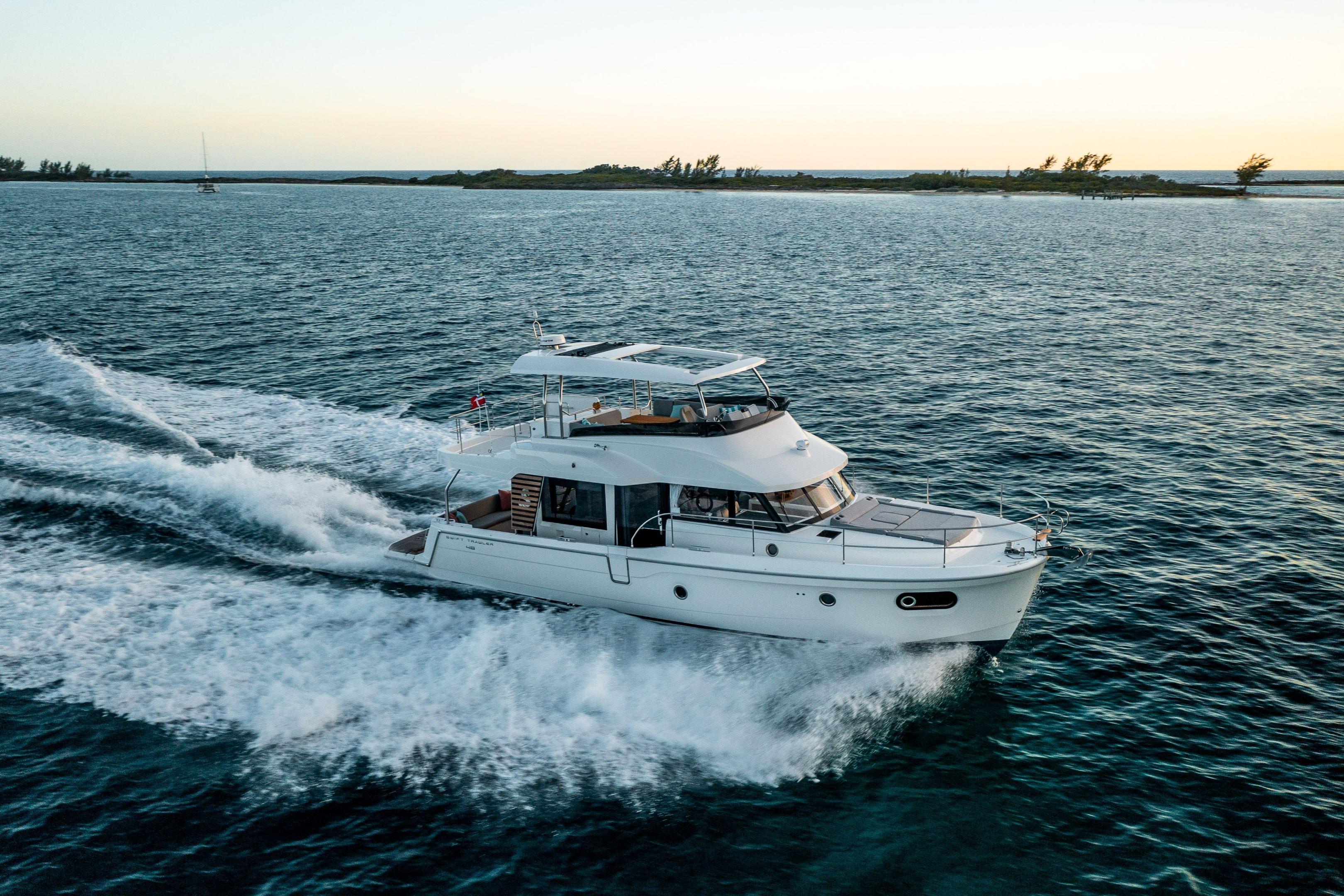 2026 Beneteau Swift Trawler 48 cruising on open water at sunset.