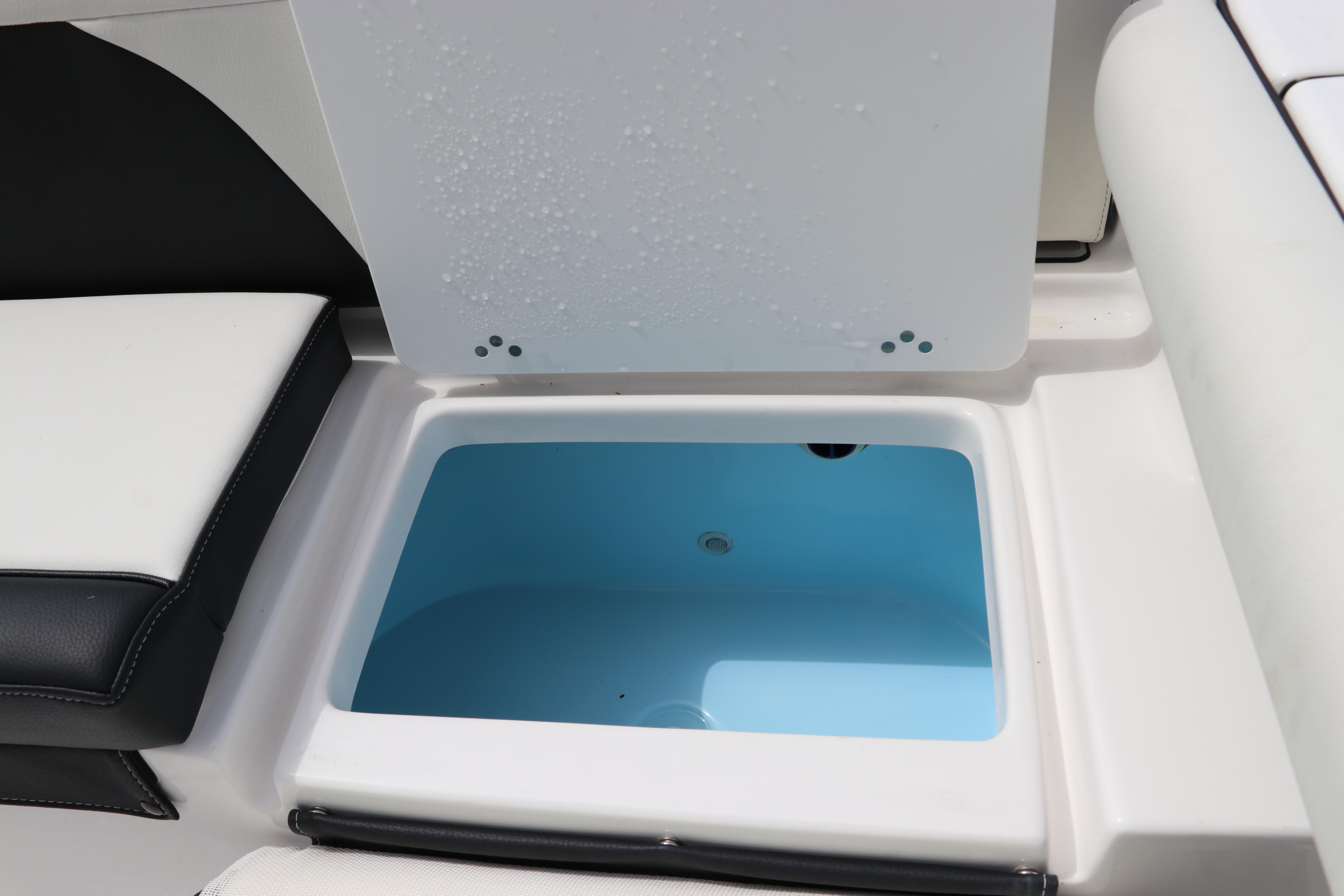 2024 Tidewater 256 LXF boat storage compartment with open lid, showcasing interior space.