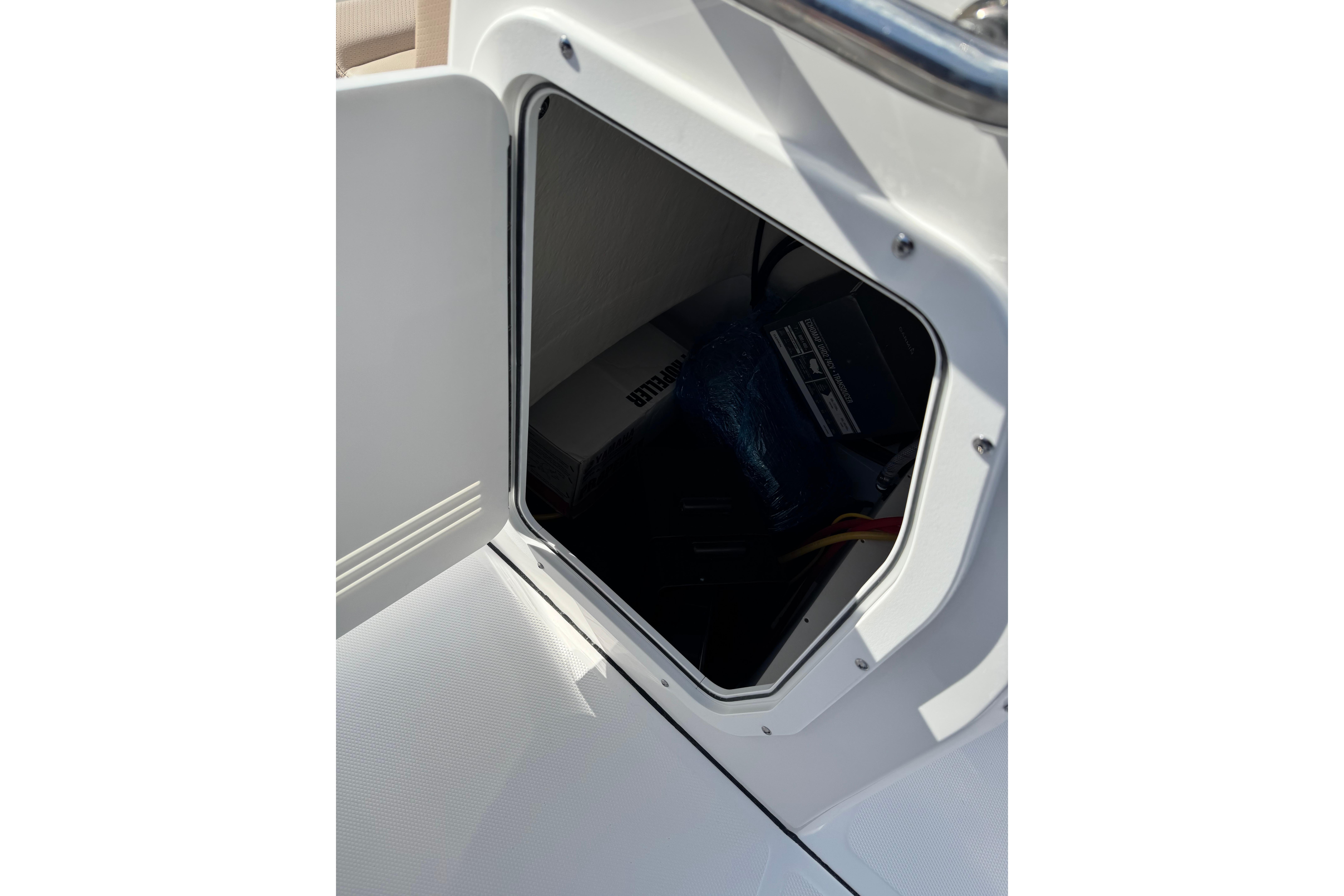 Open storage compartment on 2026 Edgewater 170CC boat, showcasing interior details.