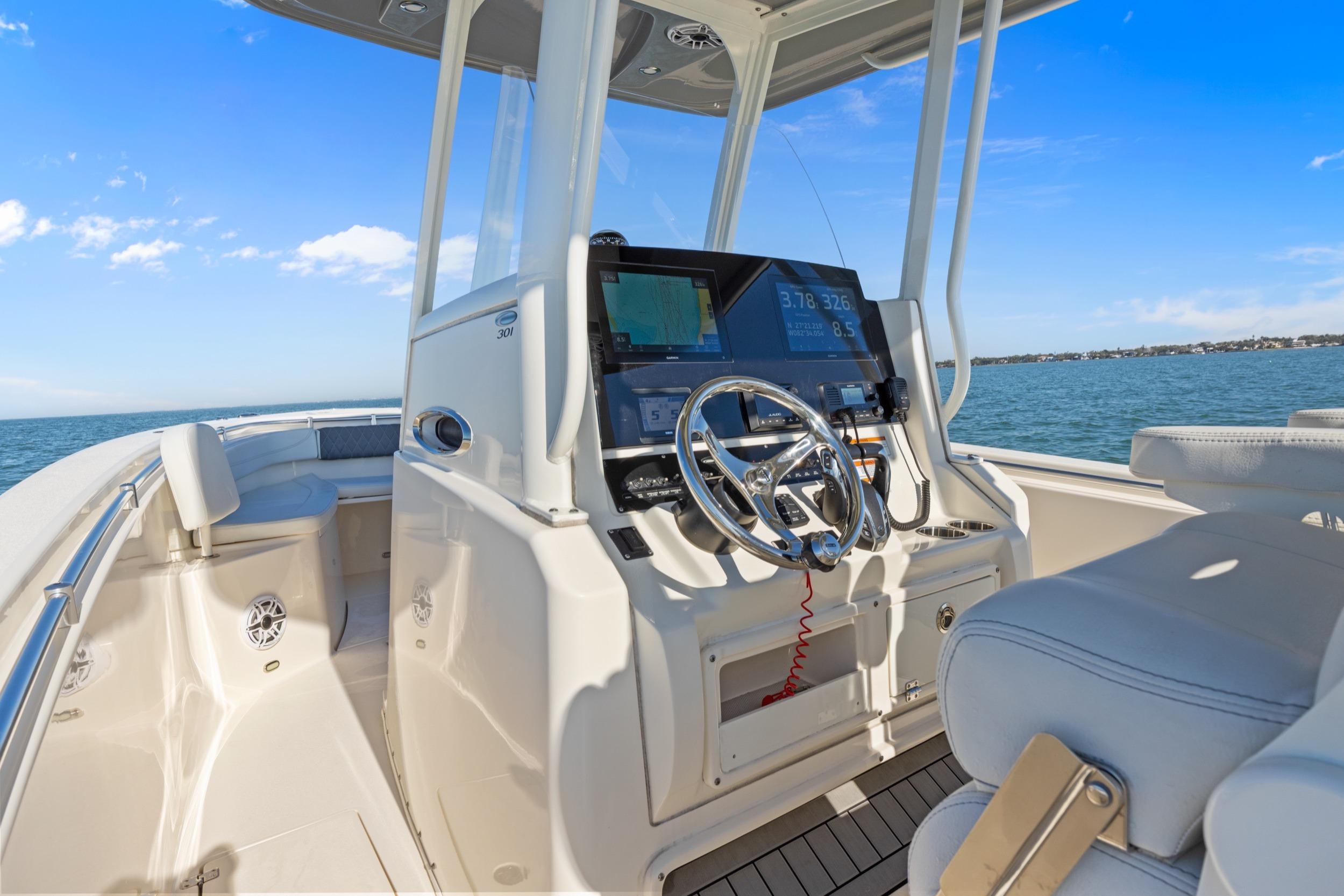 2023 Cobia 301 Center Console boat interior with steering wheel and navigation system.