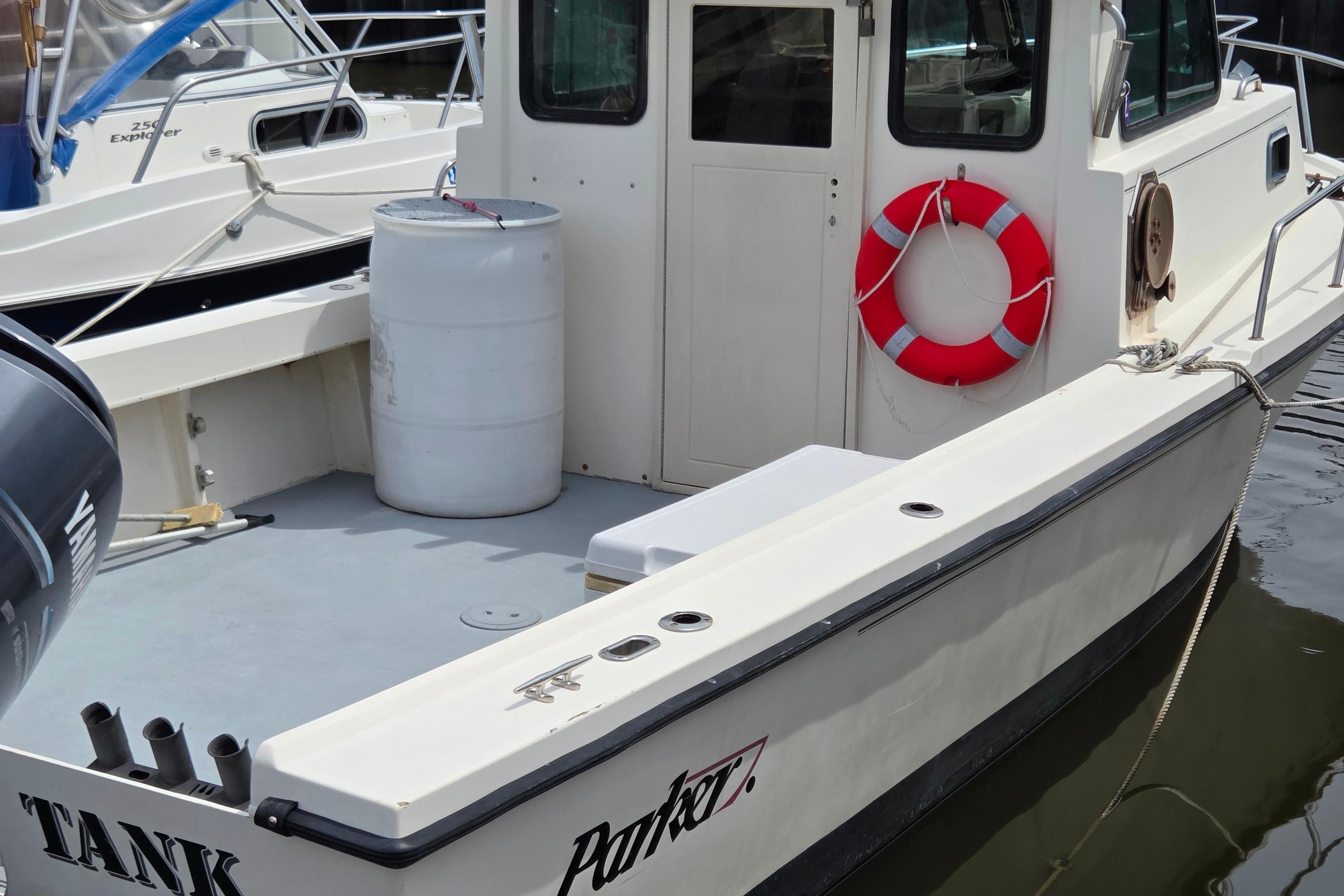 2002 Parker 2520 Deep Vee Sport Cabin boat docked with life preserver and barrel.