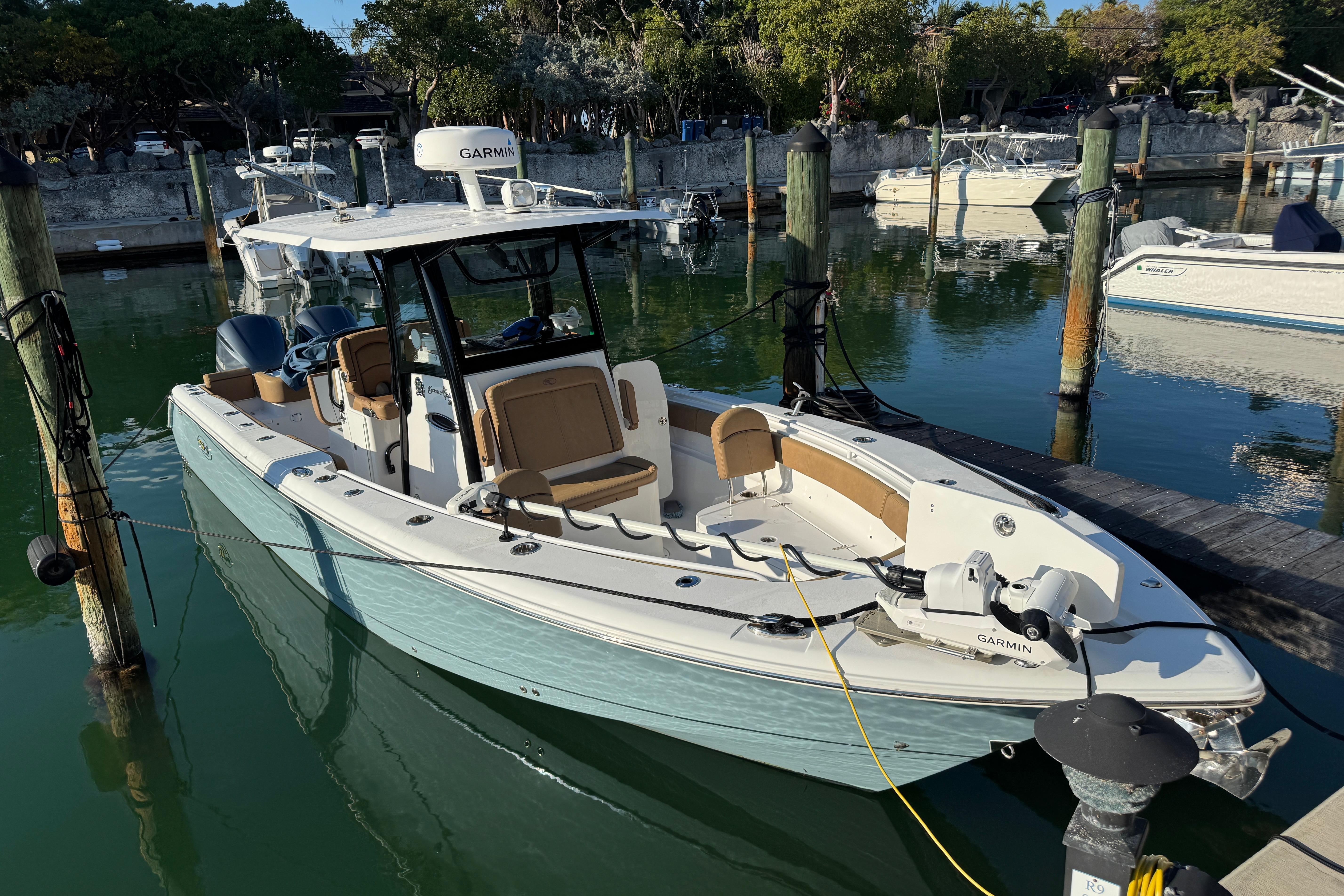 2021 Sea Hunt Gamefish 30 boat docked in a marina, featuring forward seating.
