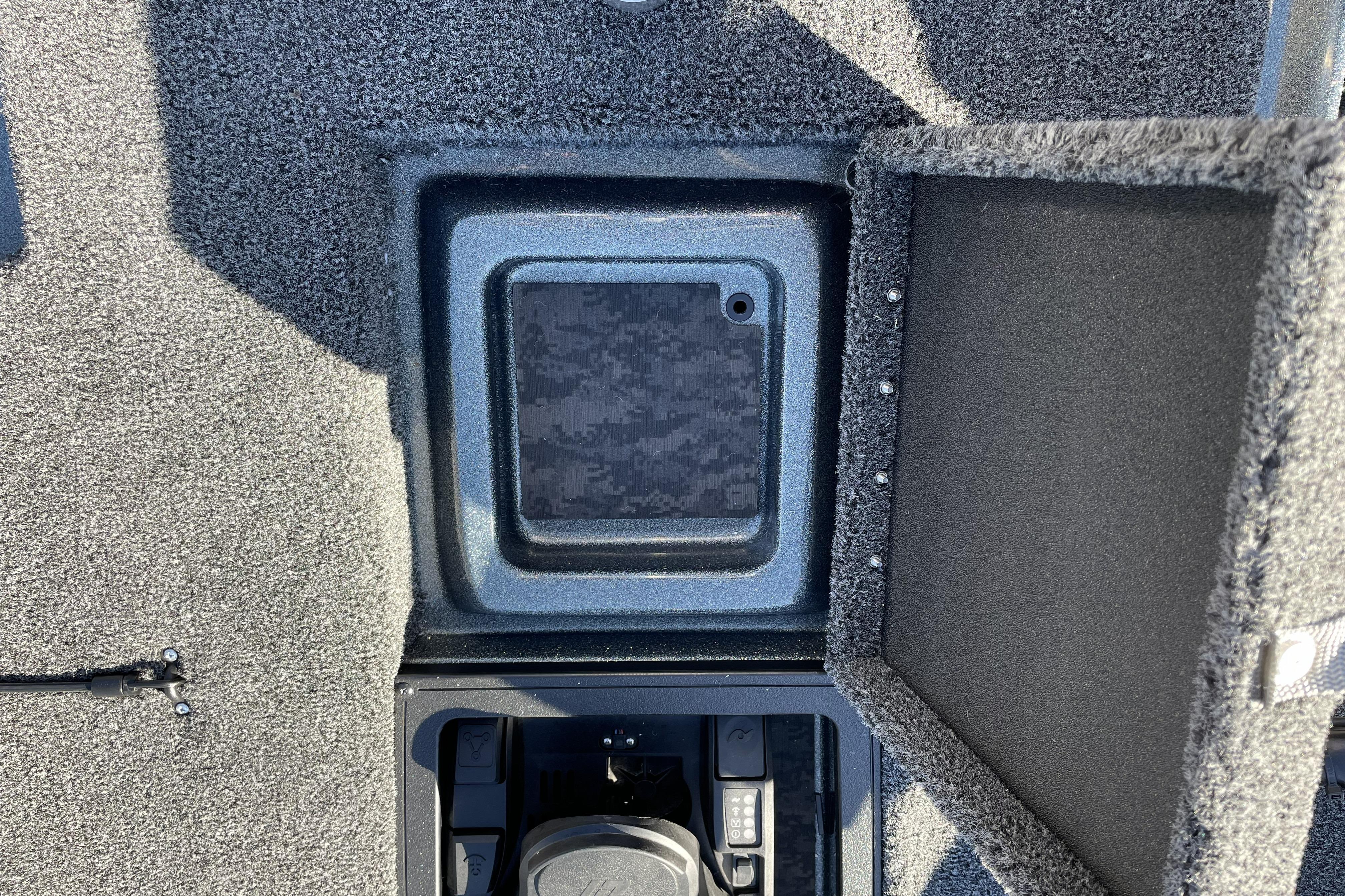 Open storage compartment in 2026 Nitro Z20 XL boat, featuring carpeted interior.