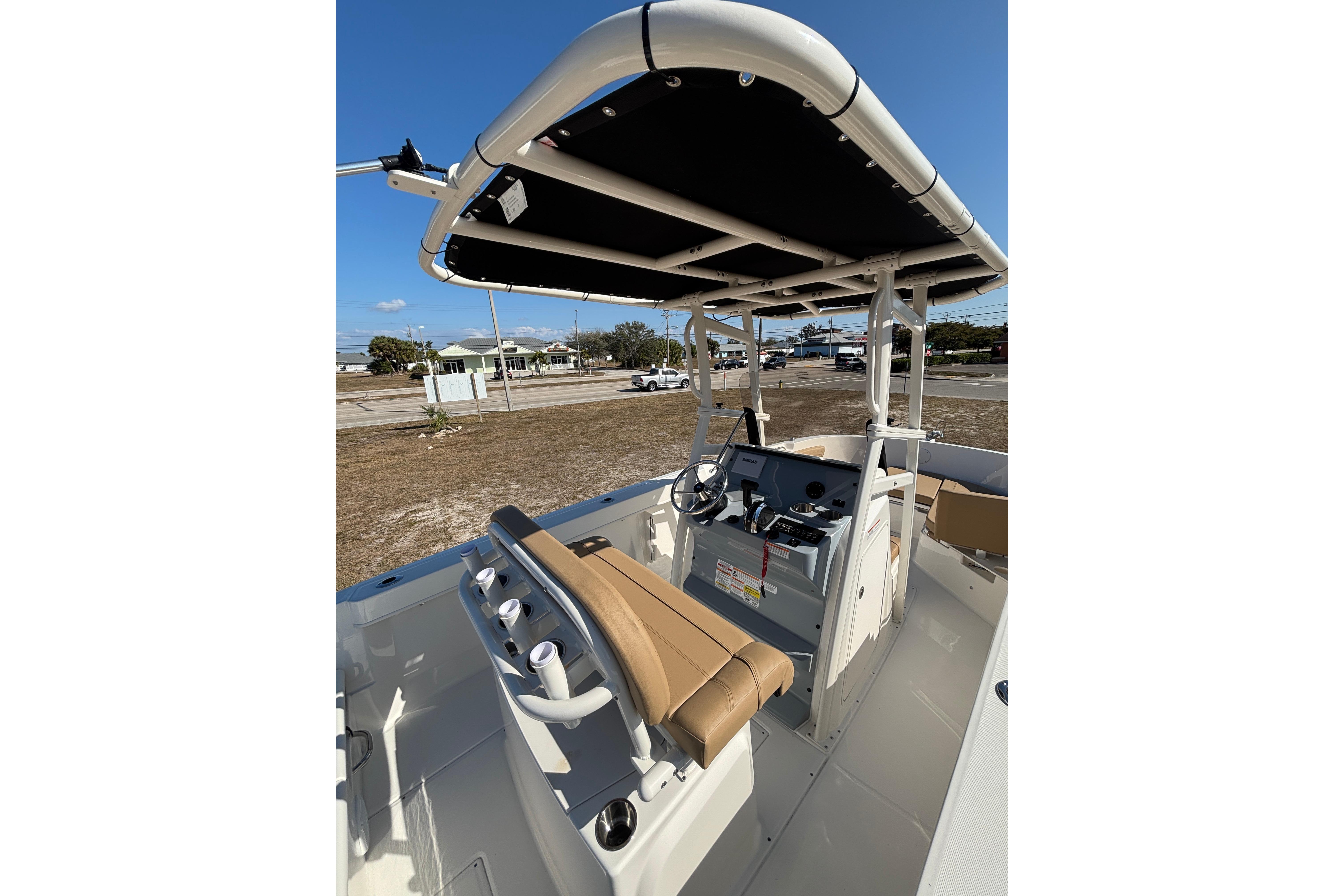 2026 Bayliner Trophy T22CC boat interior with steering console and seating under a canopy.