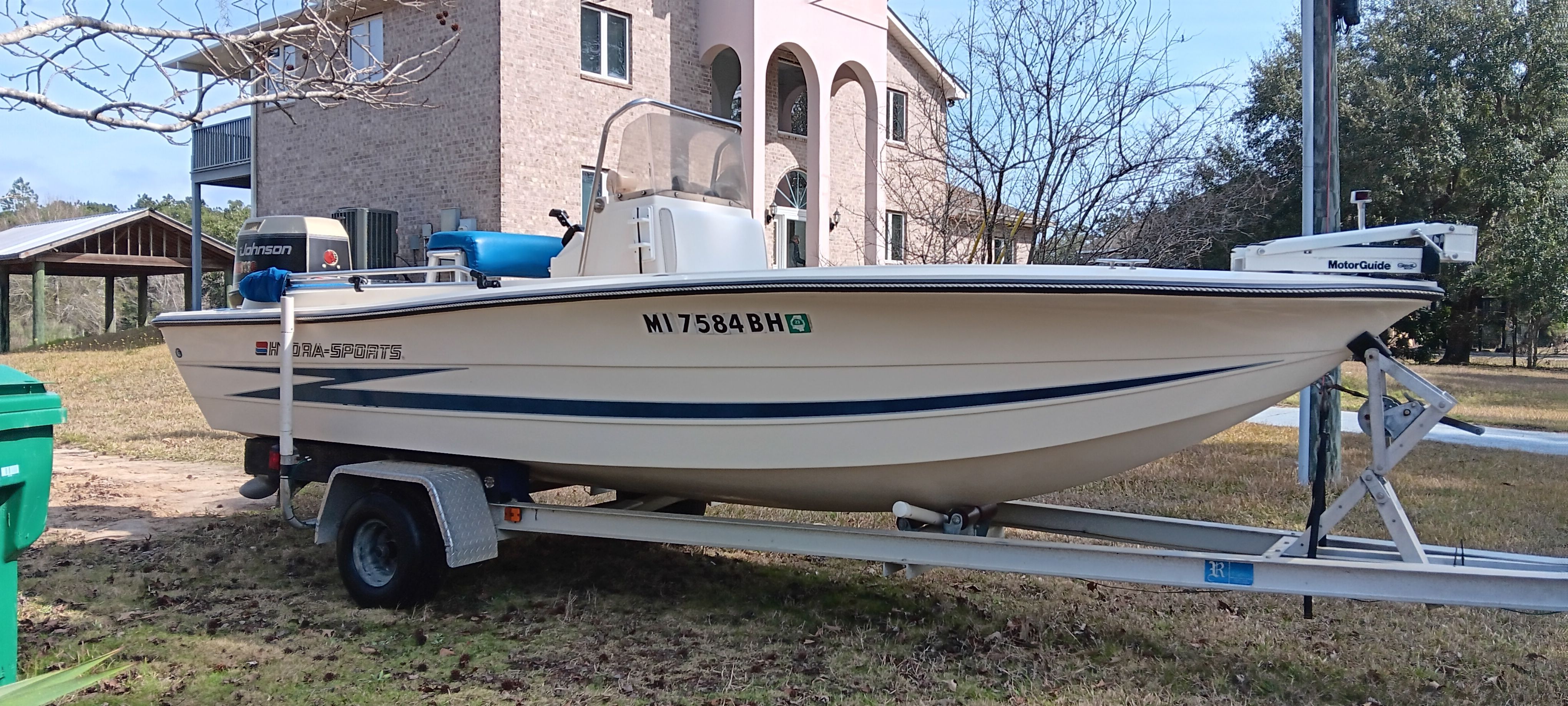 1990 Hydra-Sports Vector on a trailer parked in front of a house.