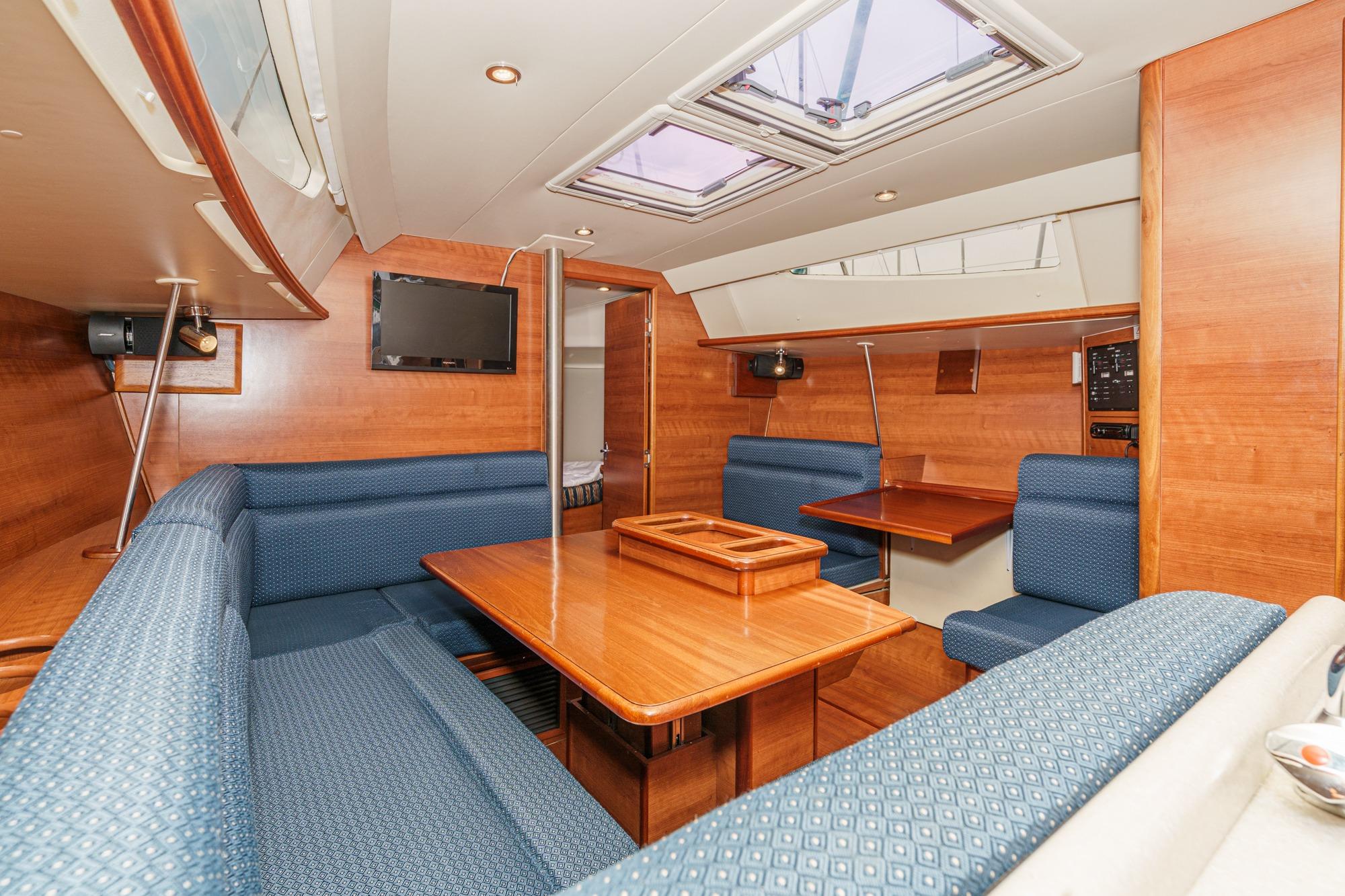 Interior of 2015 Hunter 33 sailboat with wood finish and blue seating.
