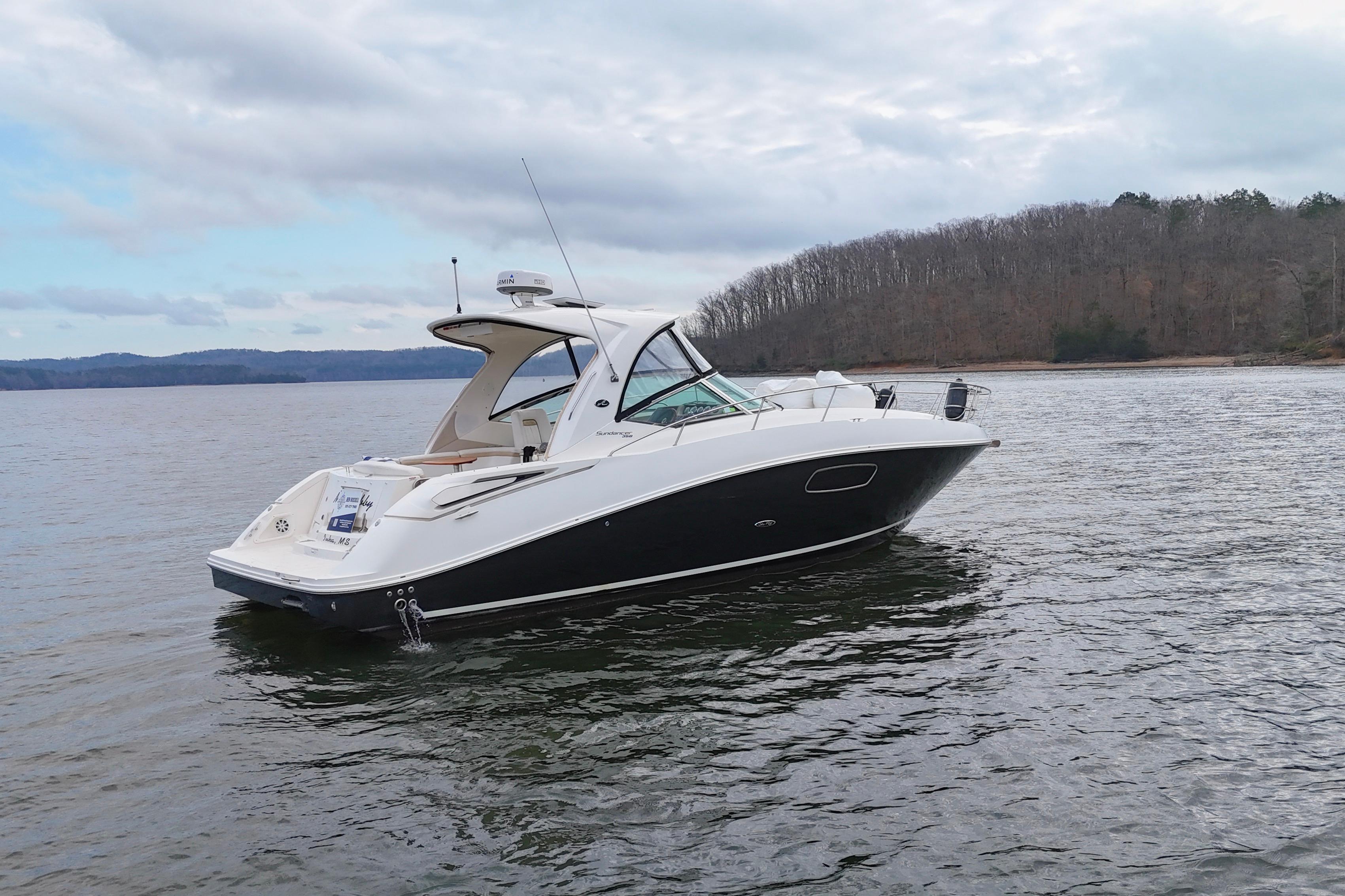 2009 Sea Ray Sundancer 350 yacht on calm lake with wooded shoreline.