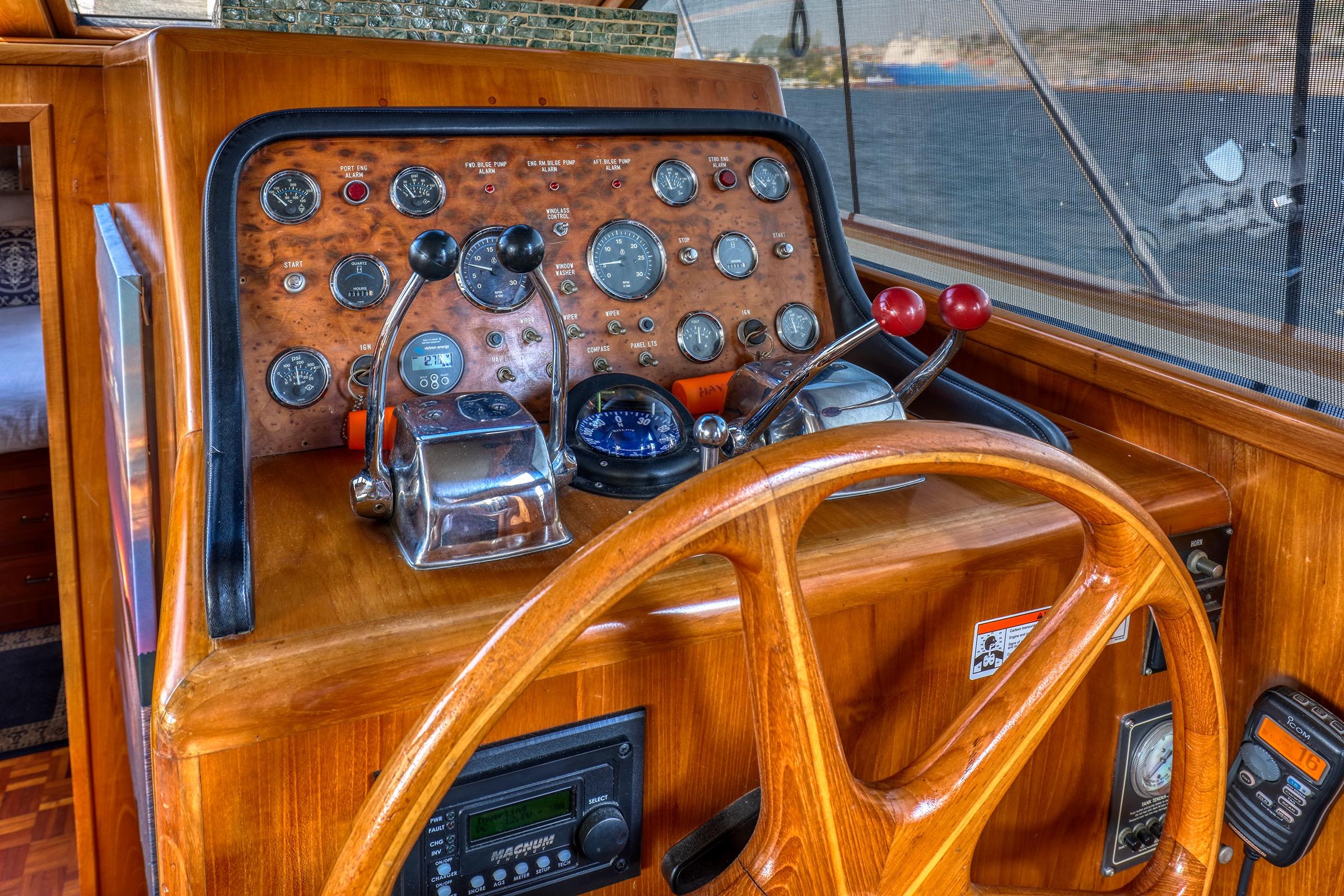 1987 Ocean Alexander 480 Sport Sedan helm with wooden steering wheel and control panel.