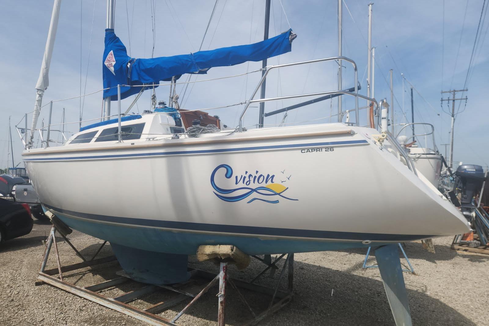 1990 Catalina Capri sailboat on stand, featuring "Vision" logo and blue sail cover.