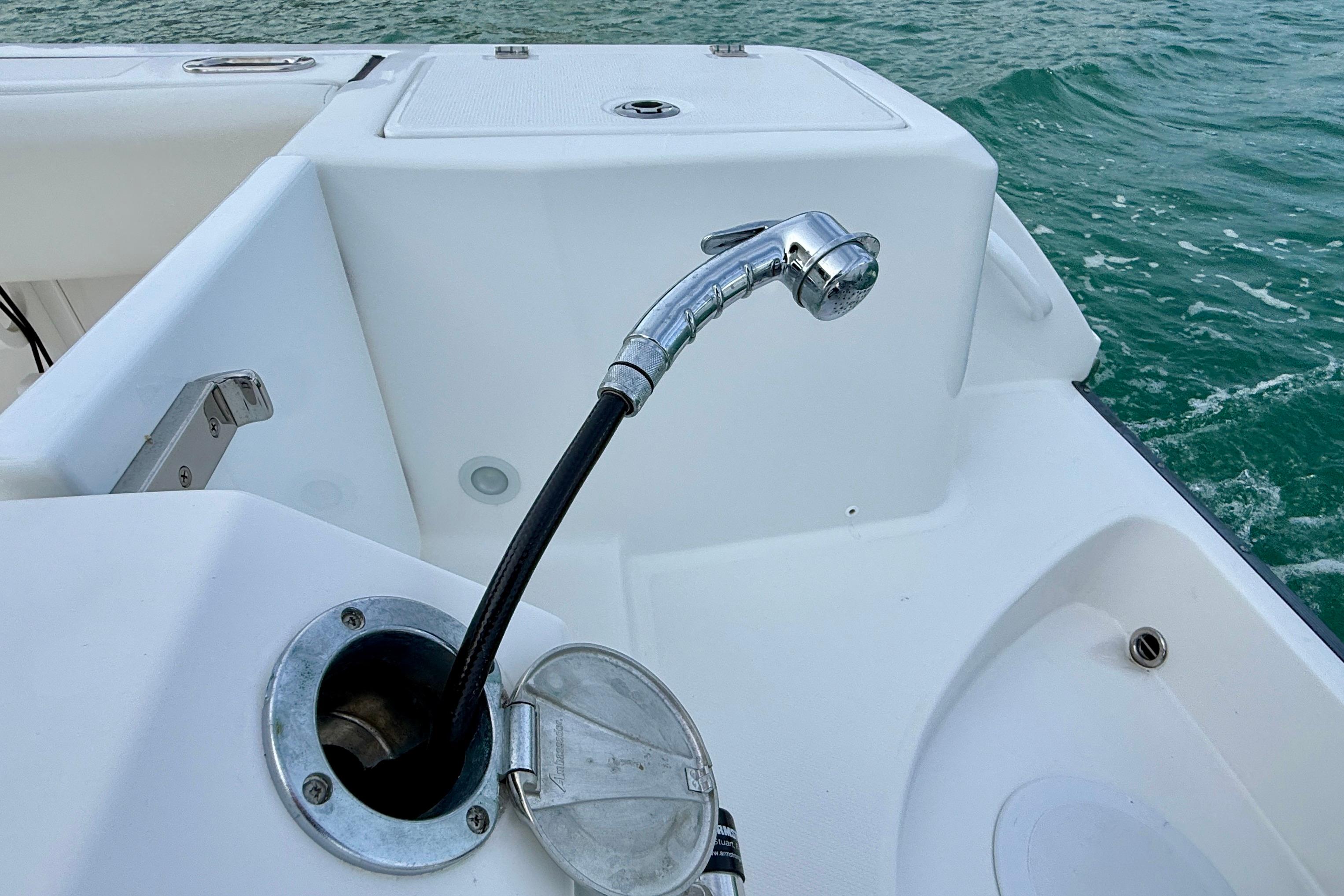 Edgewater 245CC 2023 boat deck with a chrome showerhead and ocean view.