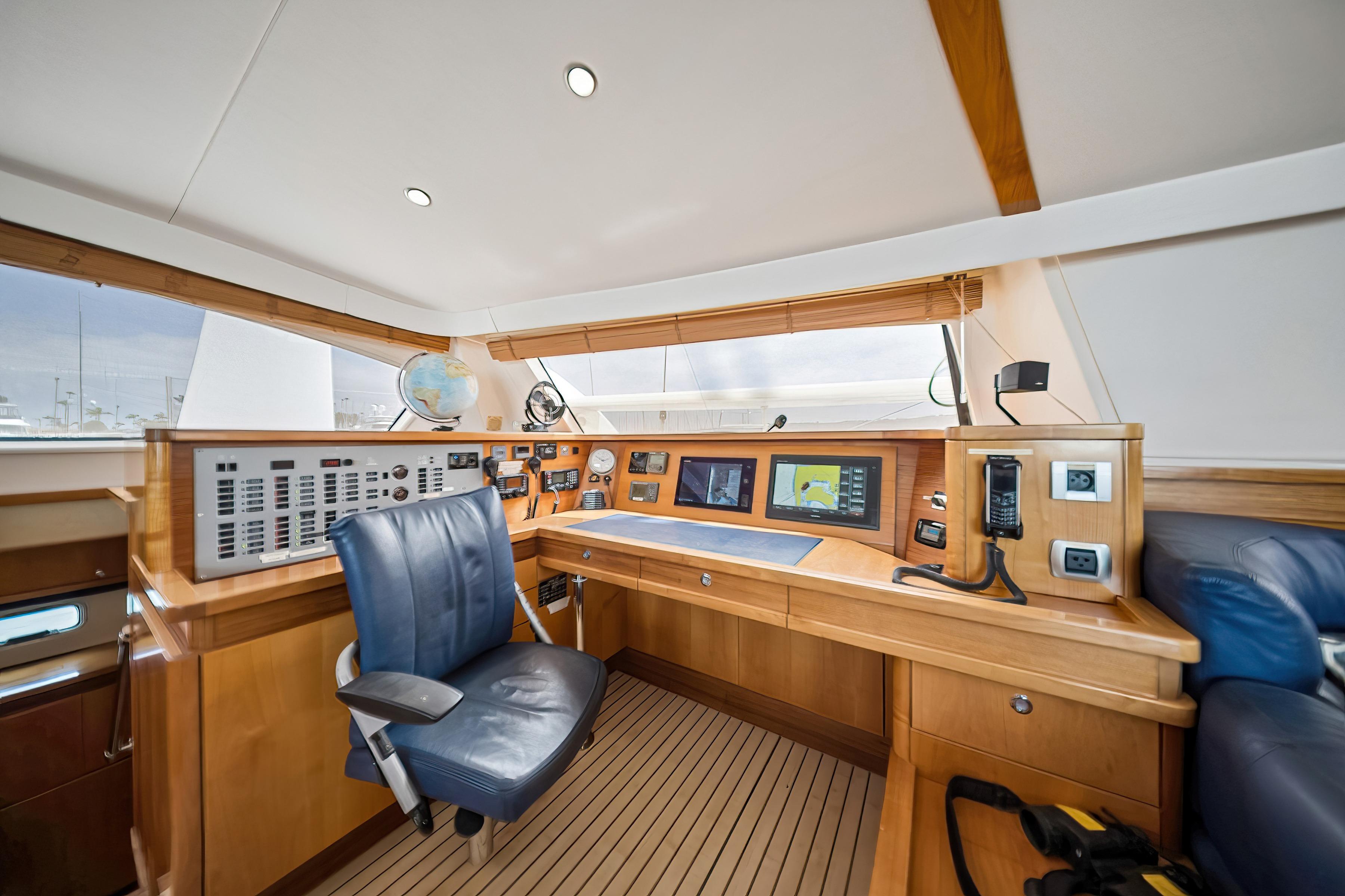 Interior helm of 2009 Catana 65 yacht with navigation equipment and blue captain's chair.