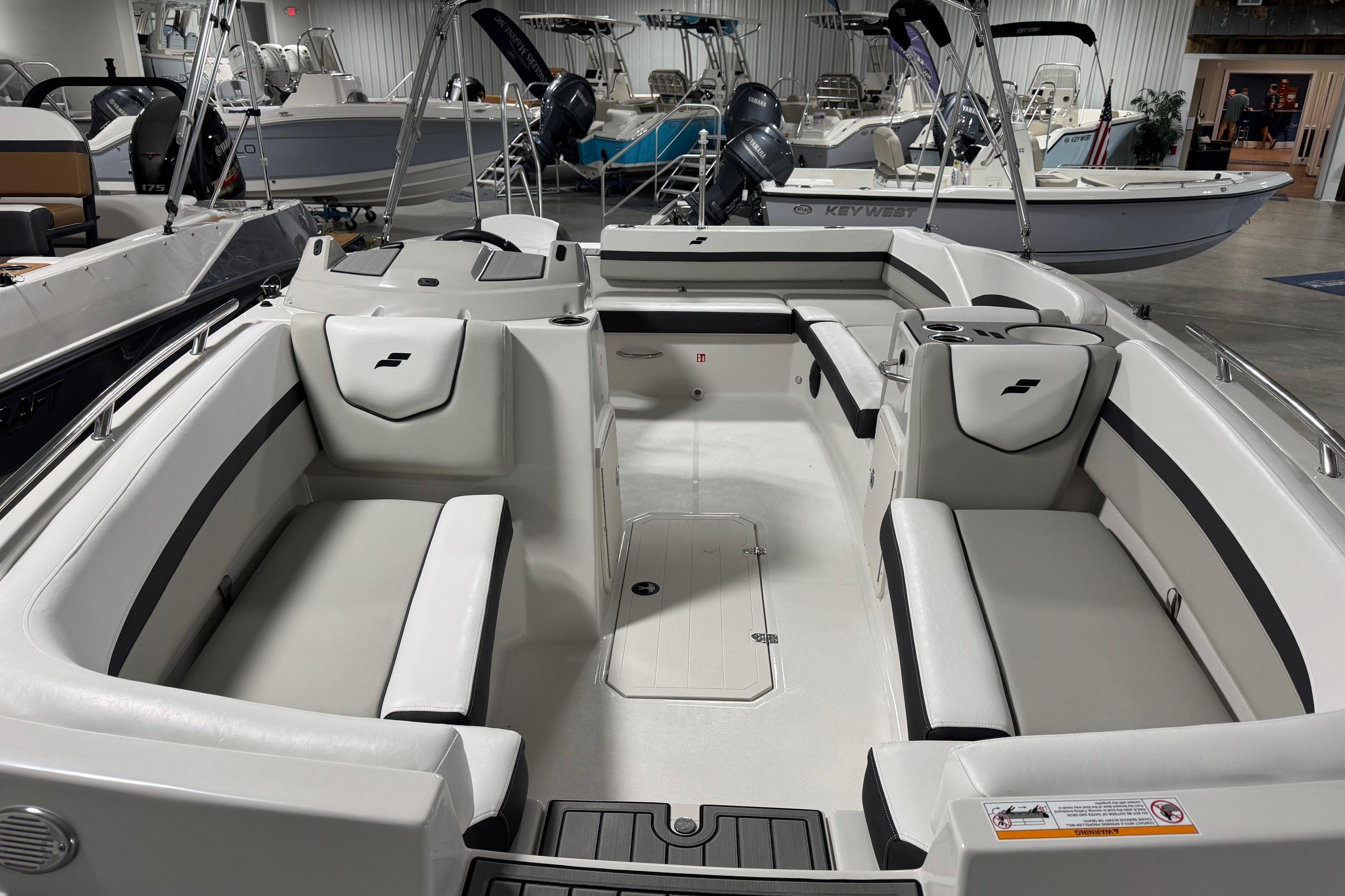 2026 Starcraft SVX 191 OB boat interior with white seating and modern design in showroom.