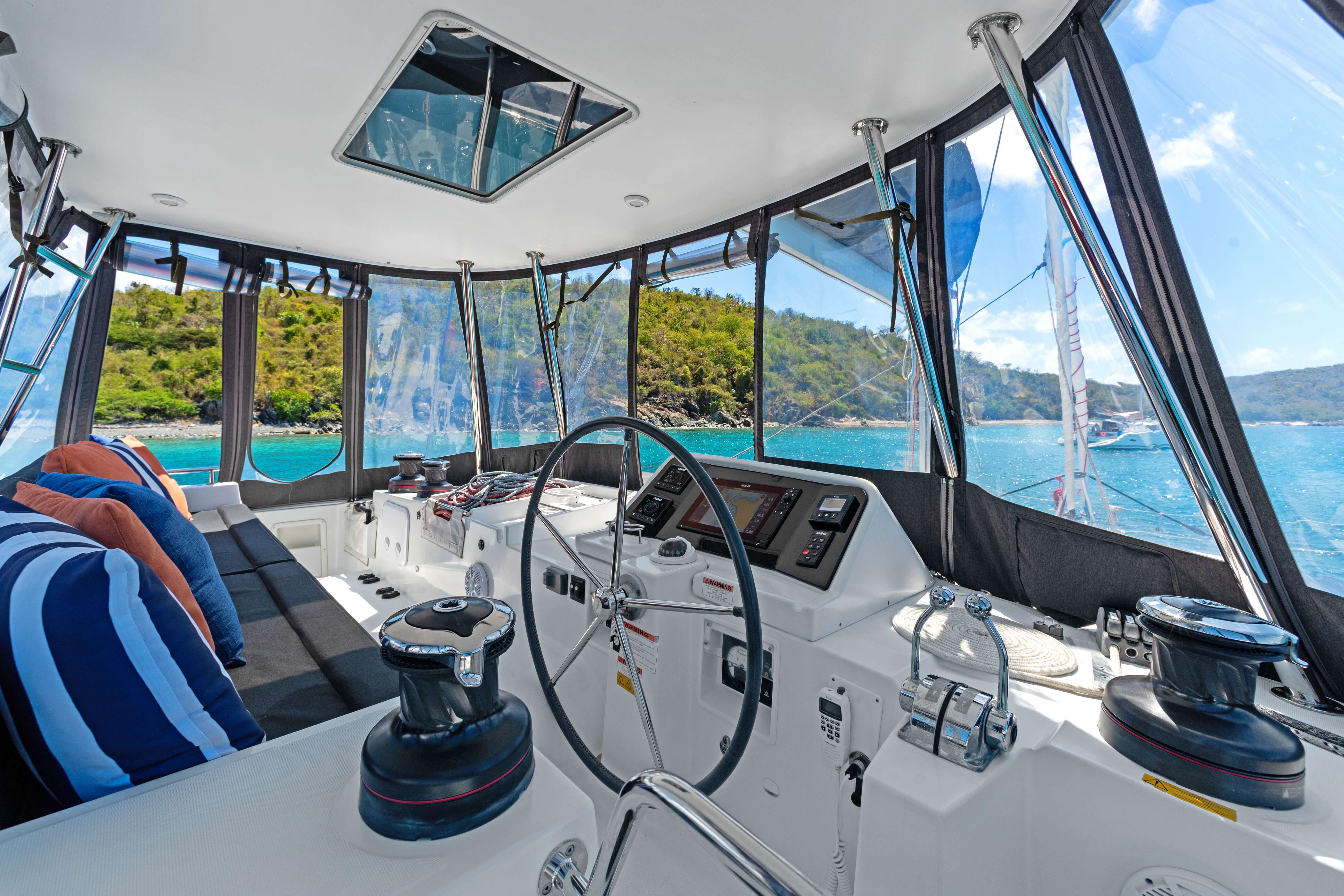 Interior view of 2017 Lagoon 450 F catamaran cockpit with scenic ocean backdrop.