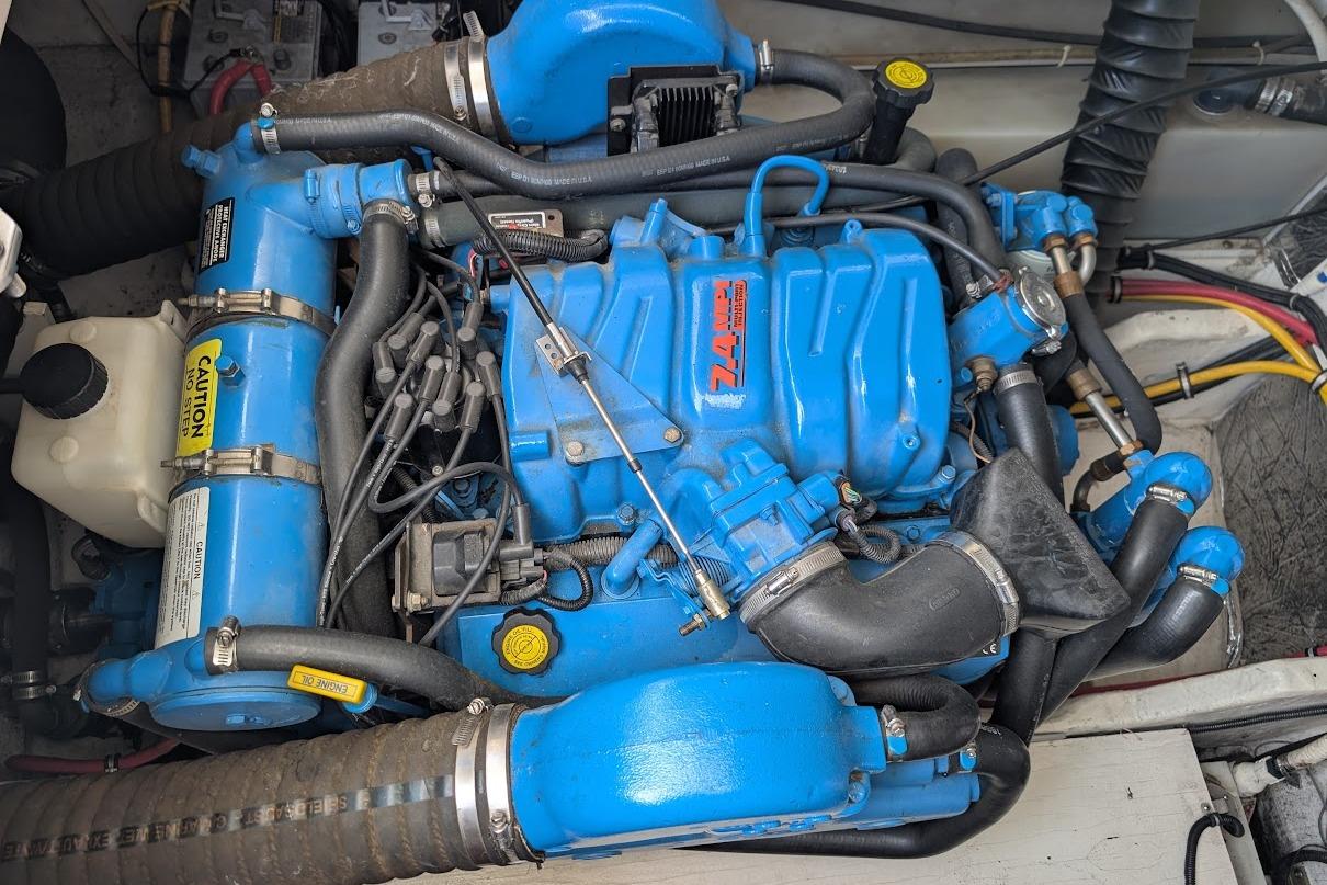Blue marine engine in a 2000 Pursuit 3400 Express boat, showcasing detailed components.