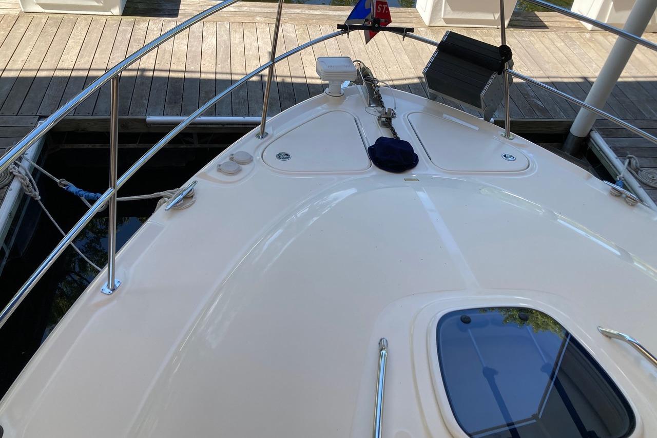 2008 Sea Ray 44 Sundancer yacht bow view at dock, showcasing deck and railings.