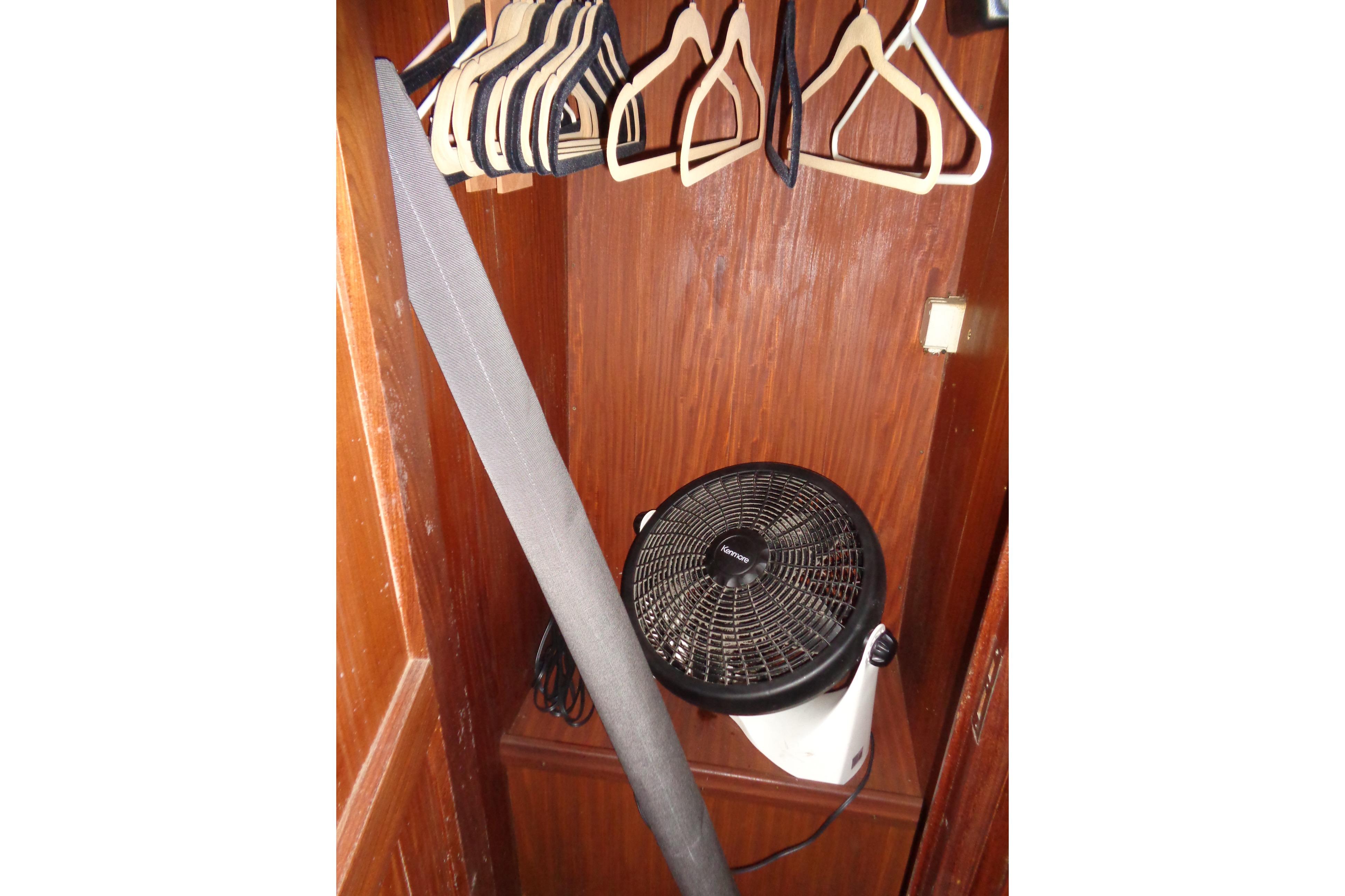 Closet in 1981 Hatteras 48 Cockpit Motor Yacht with hangers and a fan.