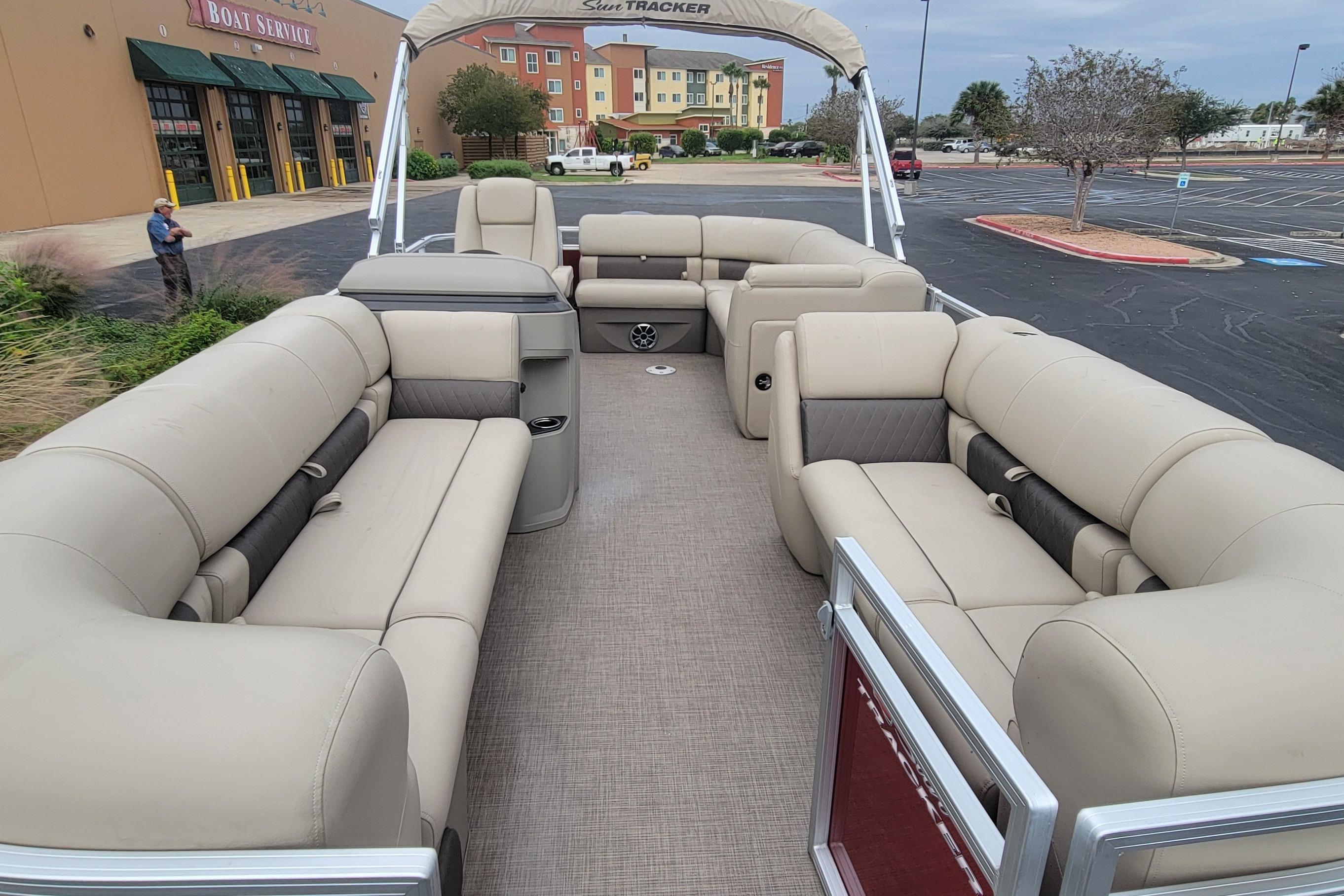 2025 Sun Tracker Party Barge 20 DLX with spacious seating in a parking lot.