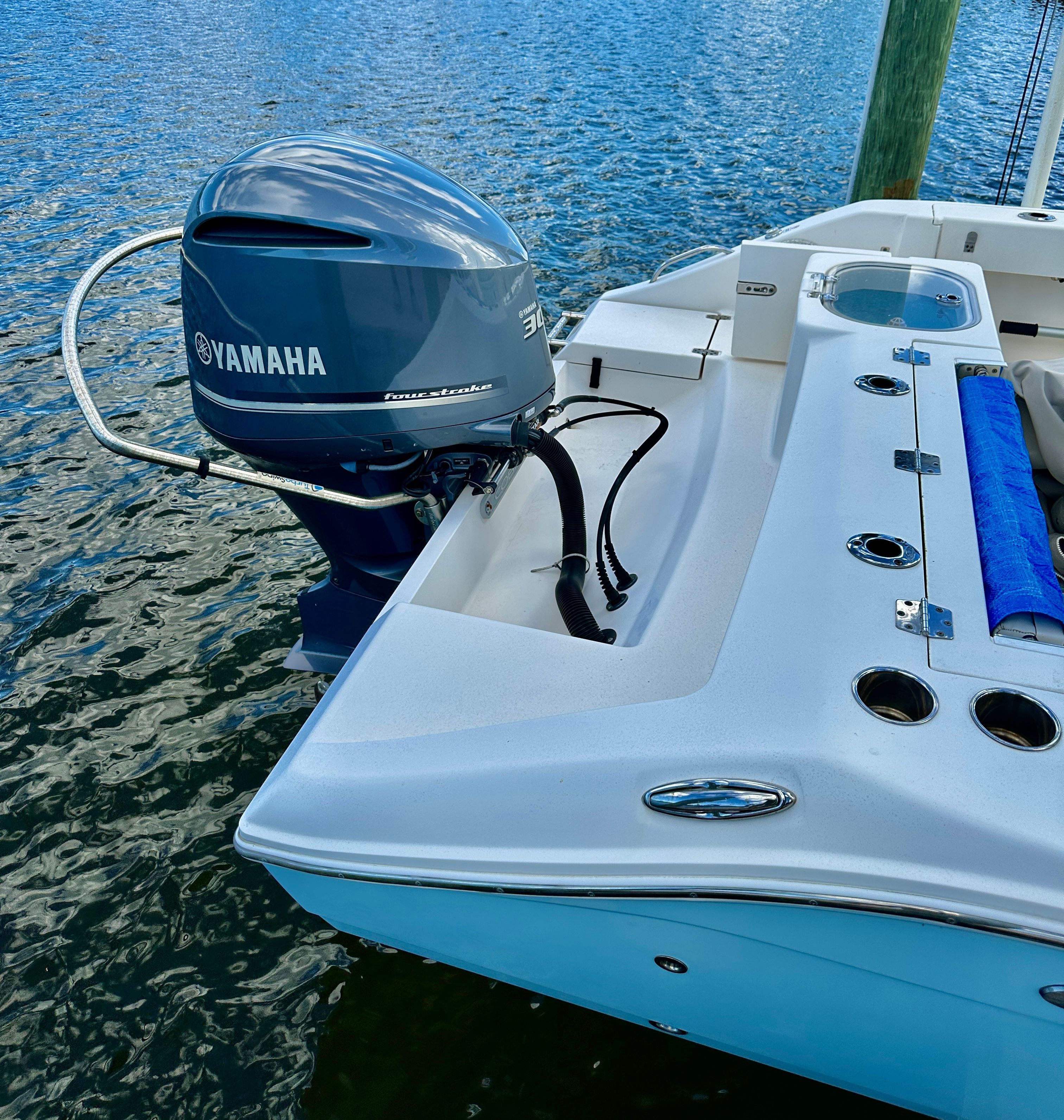 A 2022 Cobia 240 Center Console boat with a Yamaha outboard motor on calm water.