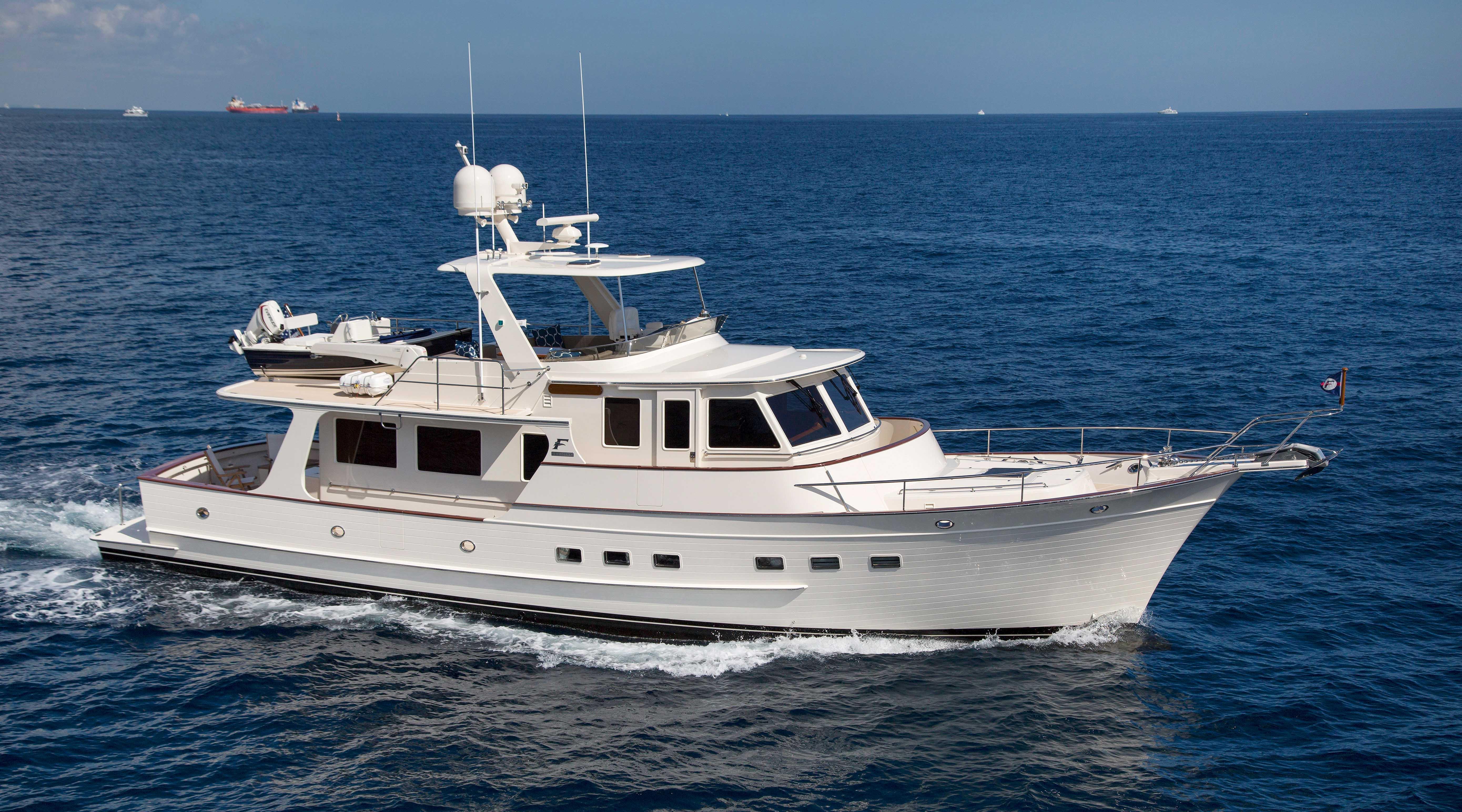 Luxurious 2027 Fleming 58 yacht cruising on open sea under clear skies.