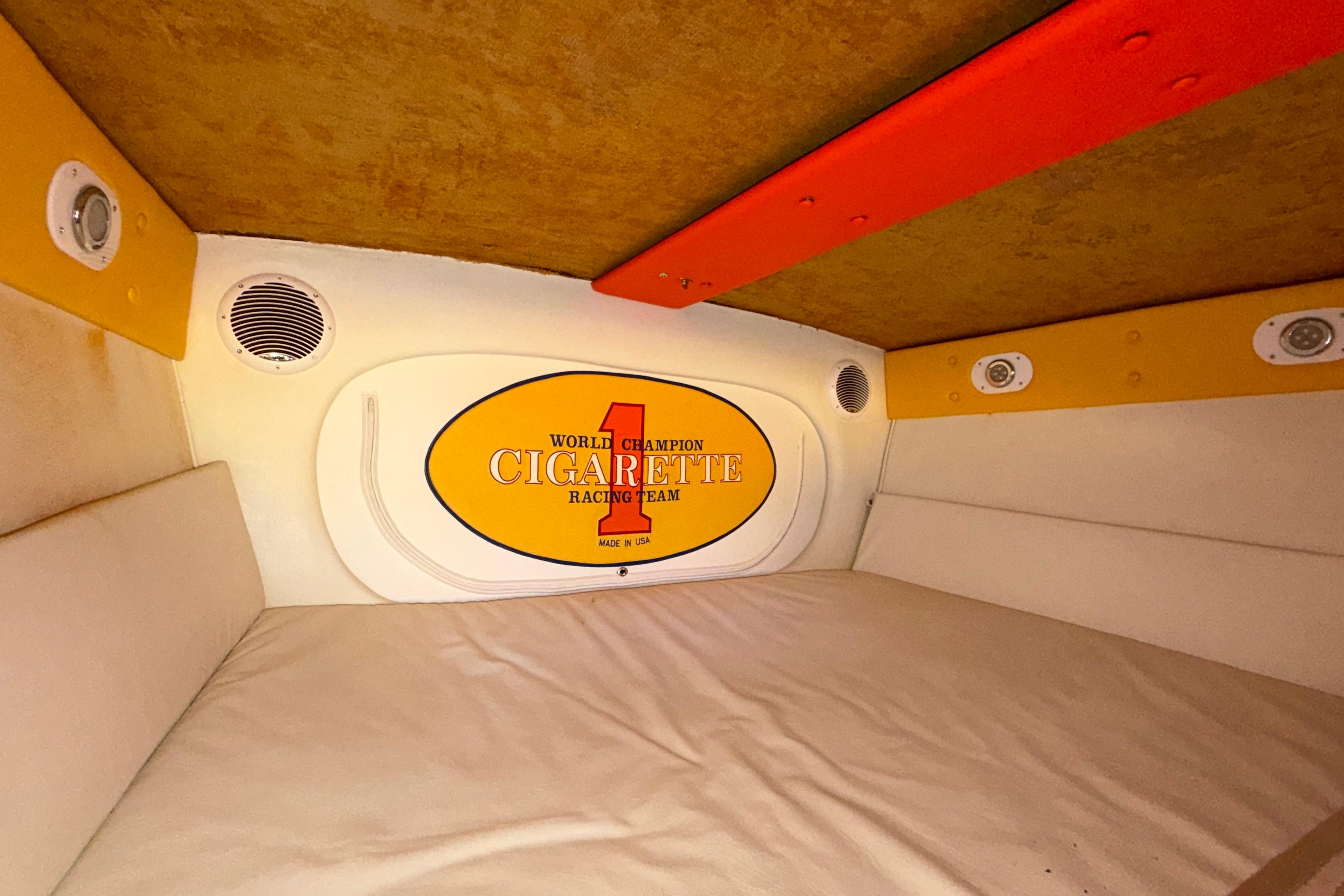 Interior cabin of 2002 Cigarette 35' Cafe Racer boat, featuring branded decor and speakers.