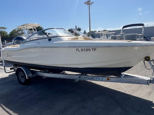 2018 Scout 210 Dorado boat on trailer in sunny outdoor setting.