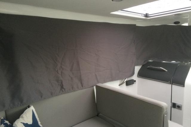 Interior of 2016 XO Boats 270 RS with covered windows and seating area.