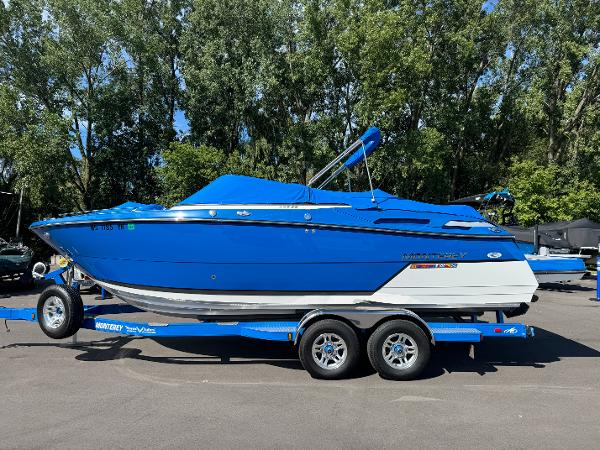2018 Monterey 258 Super Sport boat on trailer, vibrant blue, parked outdoors.