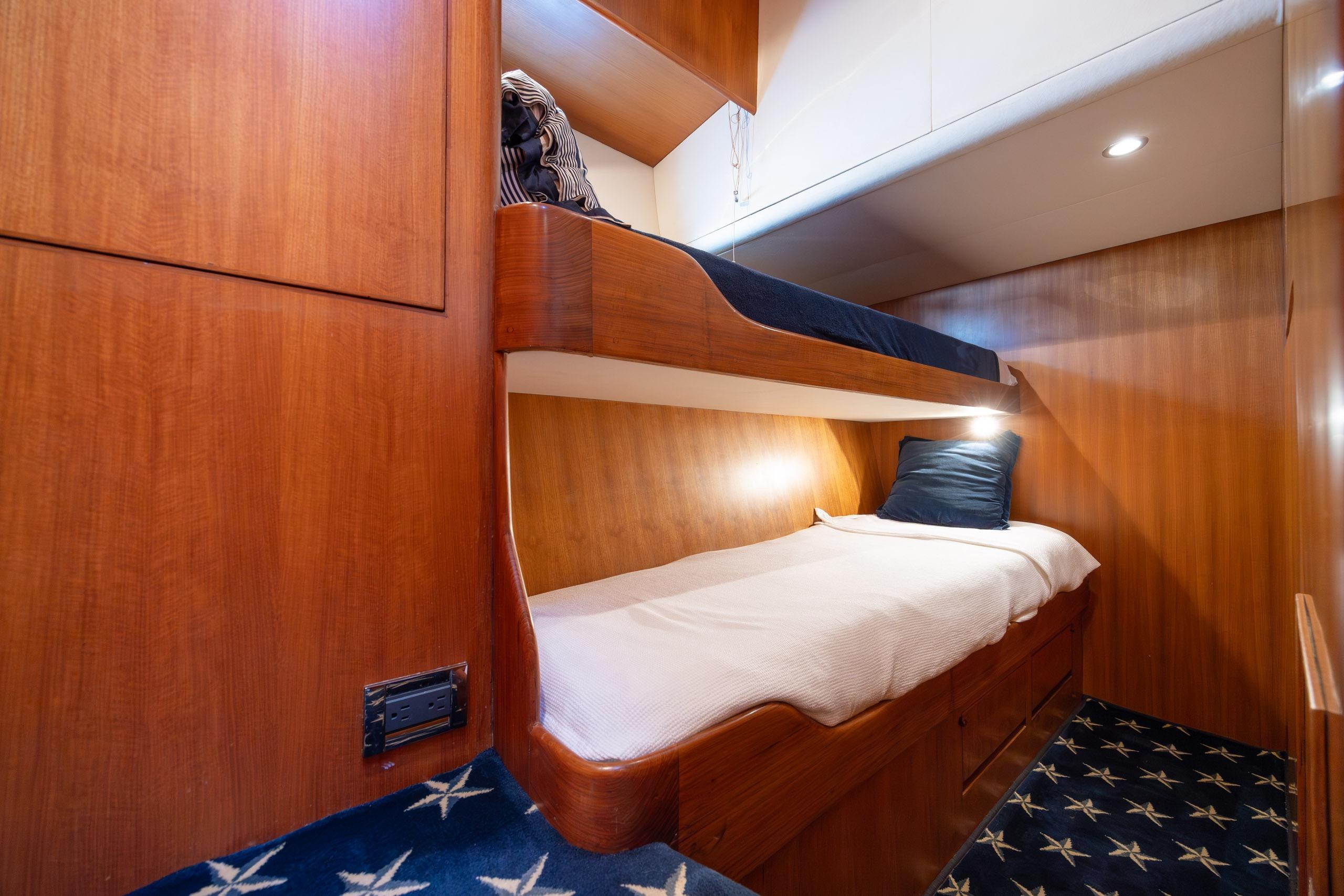 Interior of 2005 Ocean Alexander 52 Sedan yacht with wooden bunk beds and star-patterned carpet.