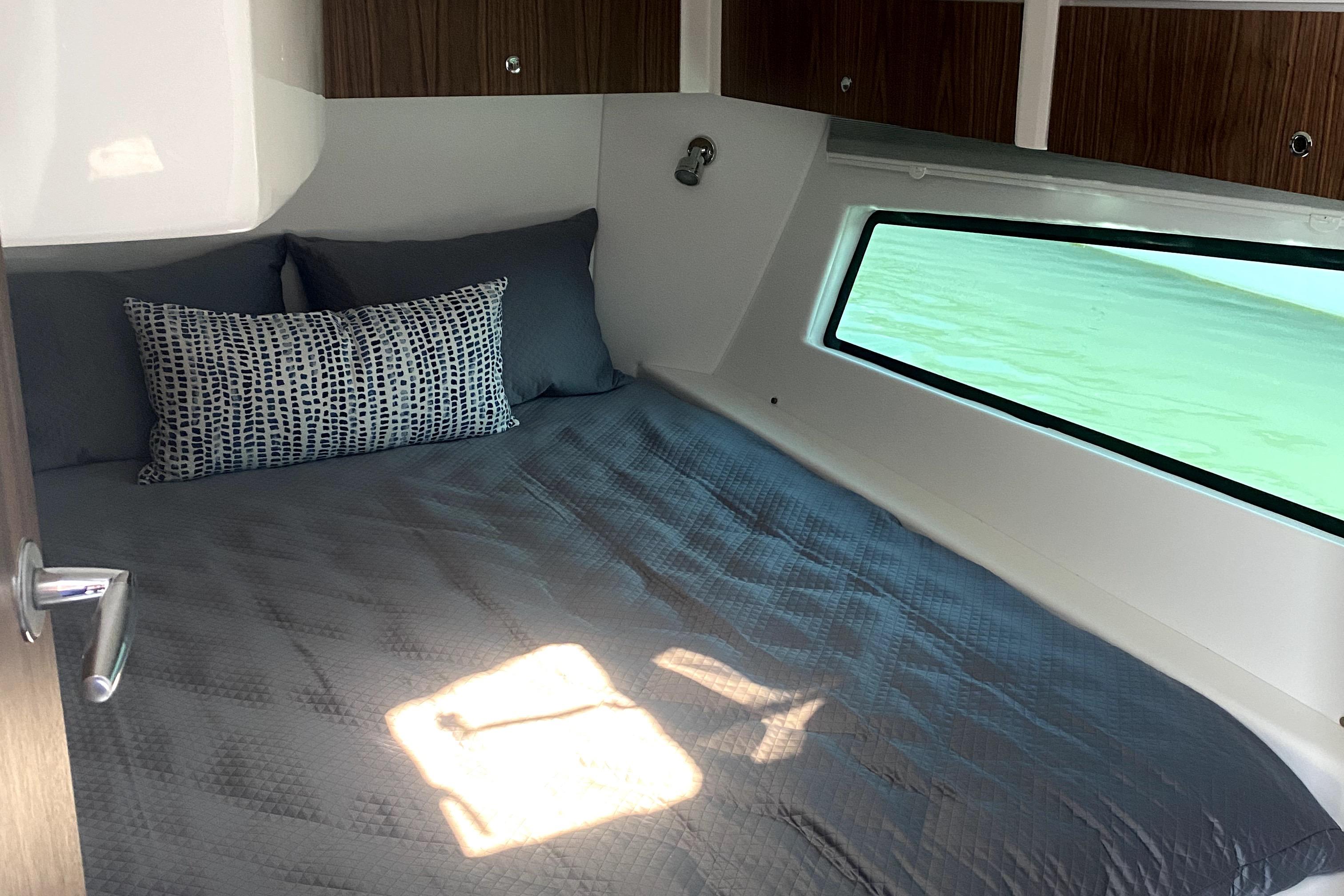 Cozy cabin interior of 2025 Intrepid 50 Evolution yacht with window view.