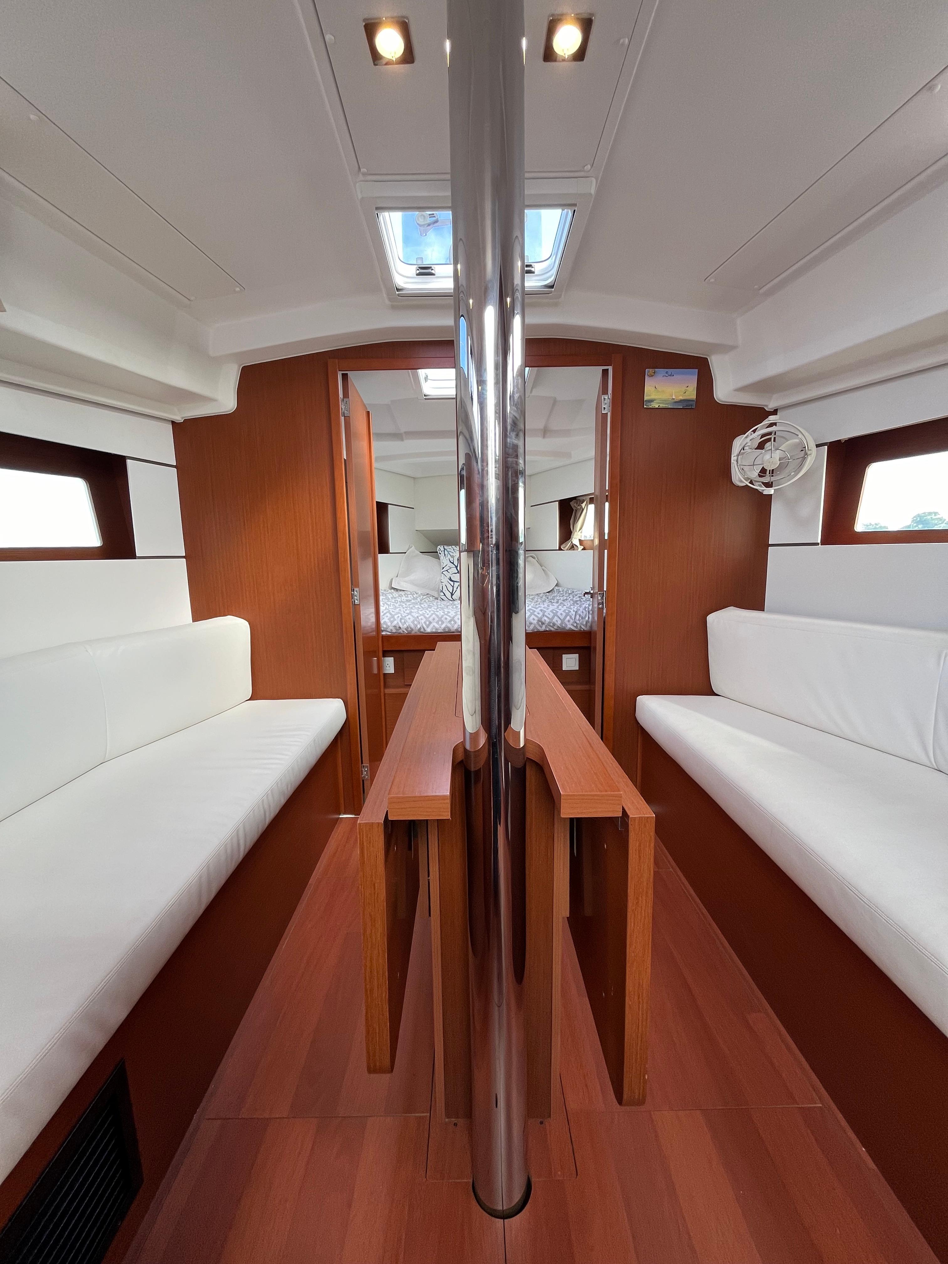 Interior of 2018 Beneteau Oceanis 35.1 sailboat with wood finish and white seating.