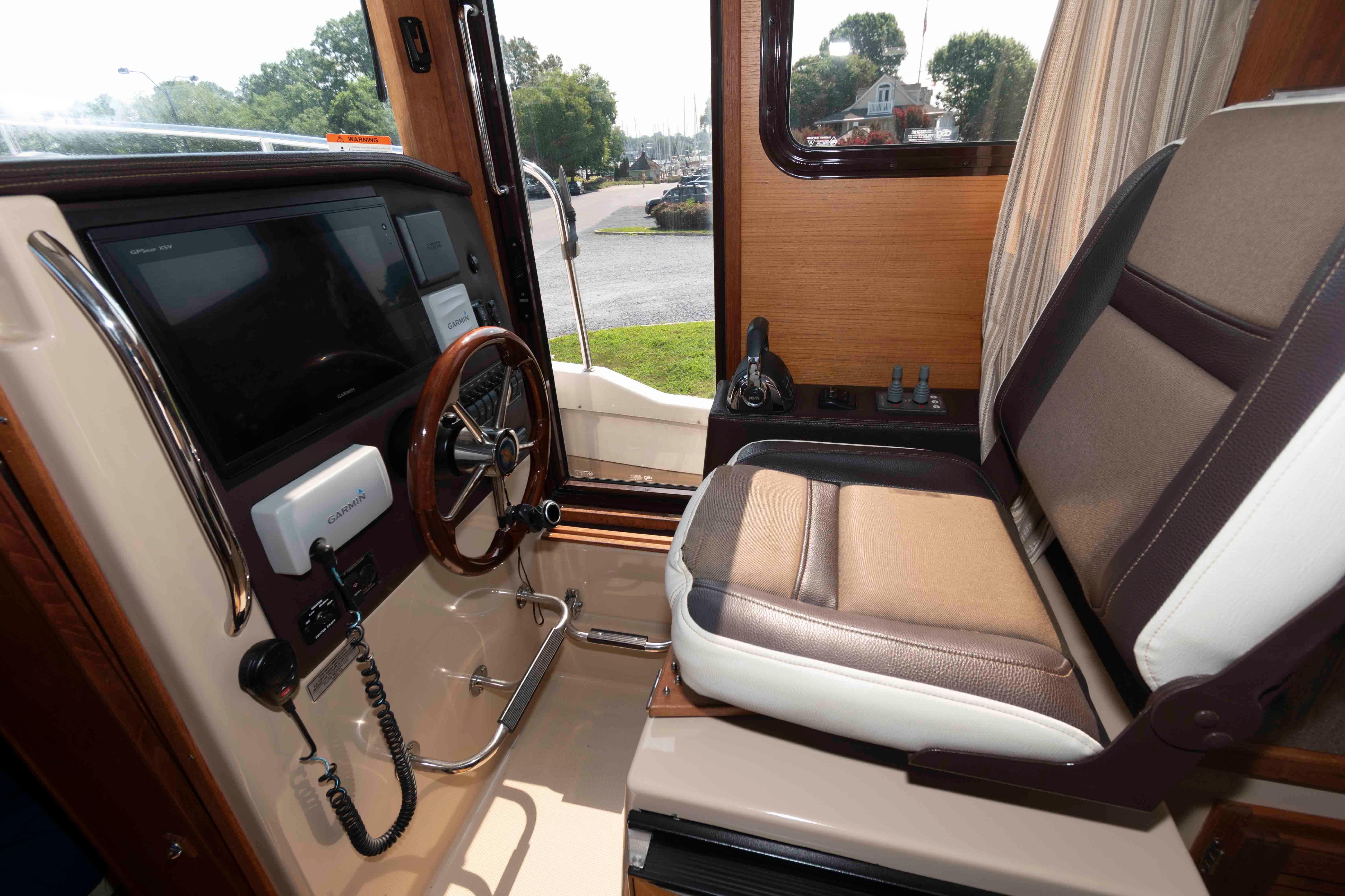 Interior helm of 2016 Ranger Tugs R-31S with steering wheel and navigation equipment.