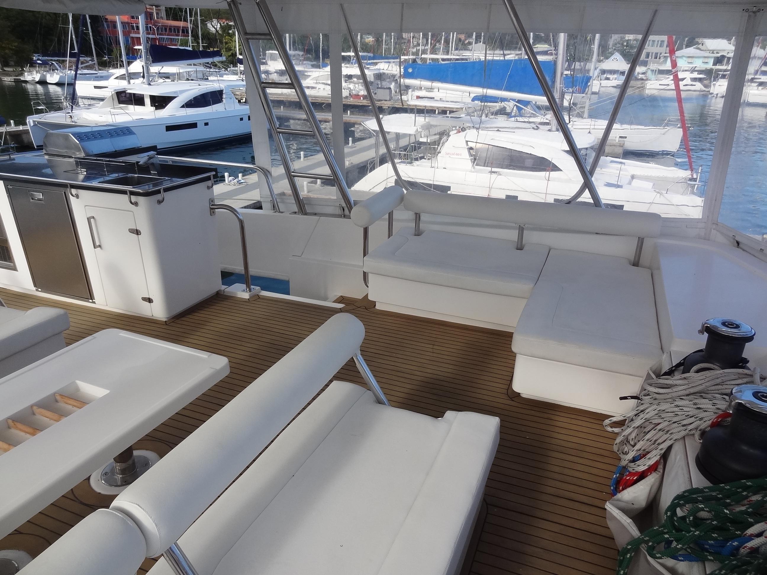 Spacious deck of 2014 Leopard 58 yacht with seating and marina view.