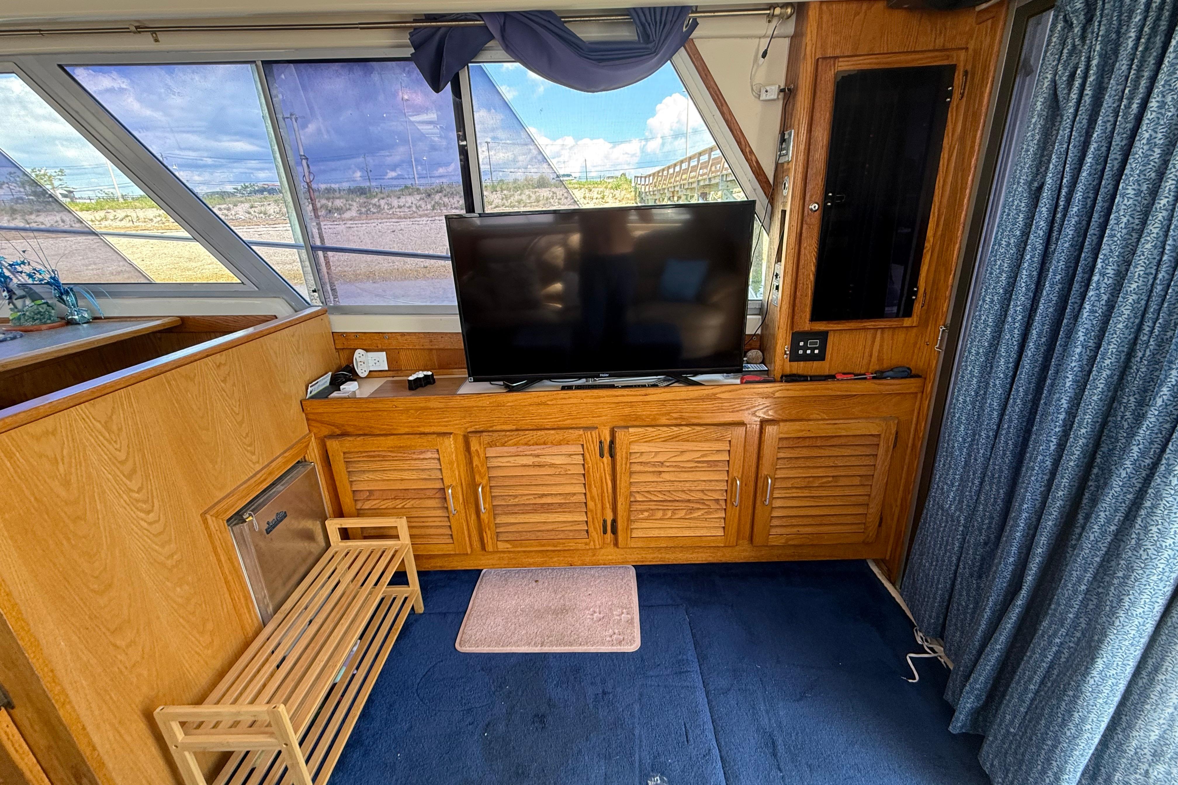 Interior of 1986 Silverton 40 Convertible yacht with wooden cabinetry and a flat-screen TV.