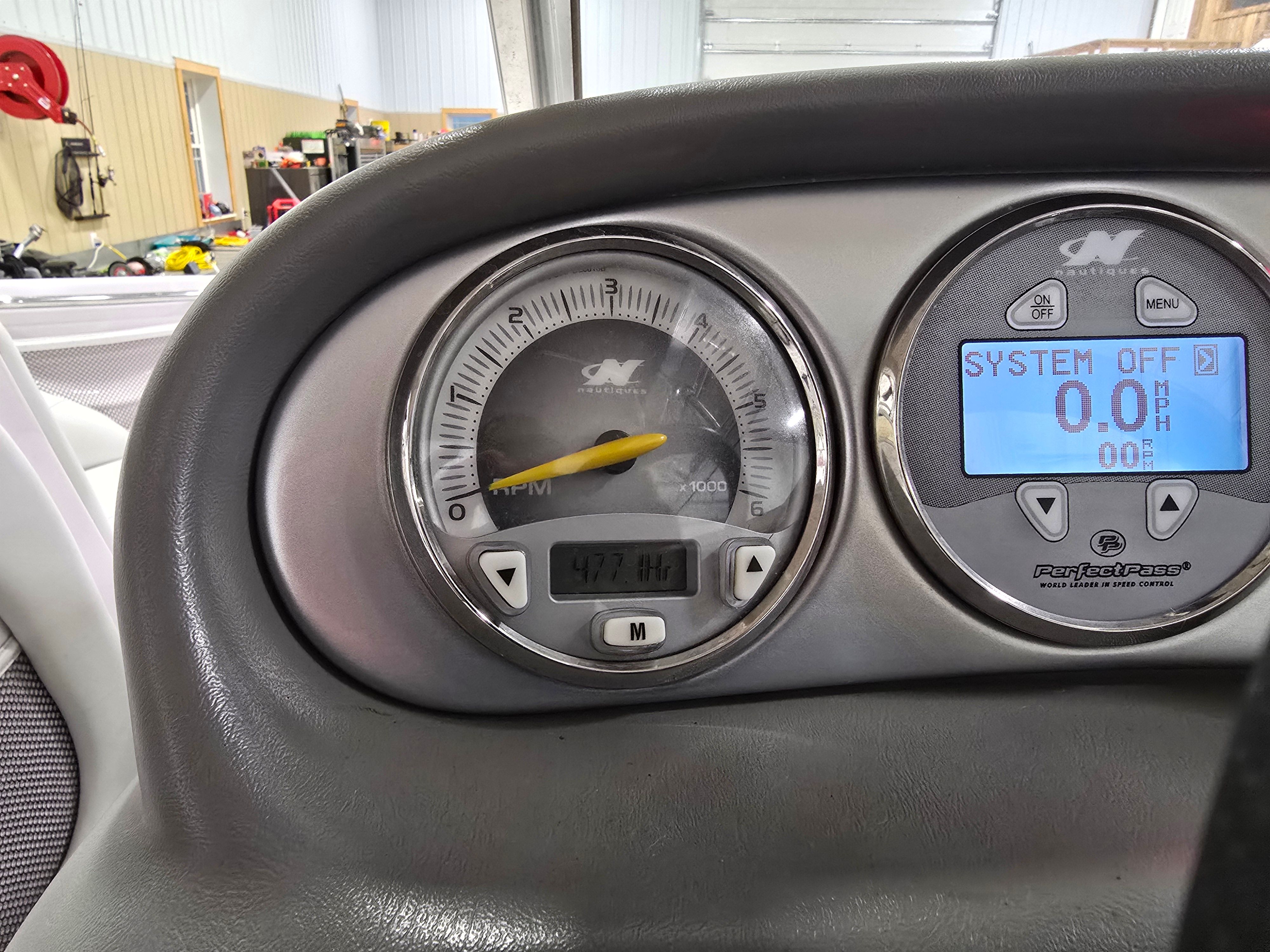 Dashboard of a 2006 Correct Craft 228 boat with tachometer and display.