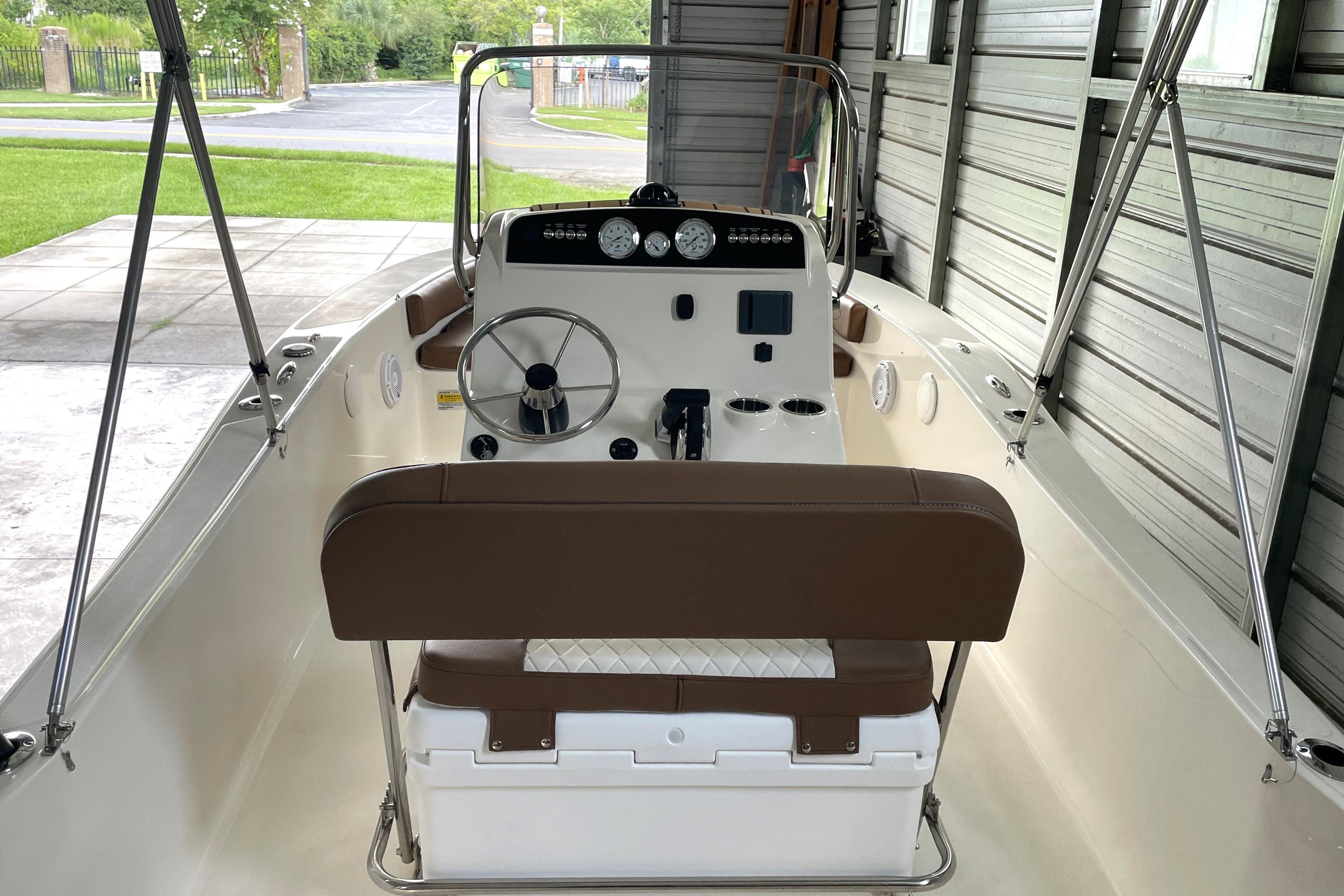 2024 Pioneer 180 Islander boat interior with steering wheel and dashboard in a garage.