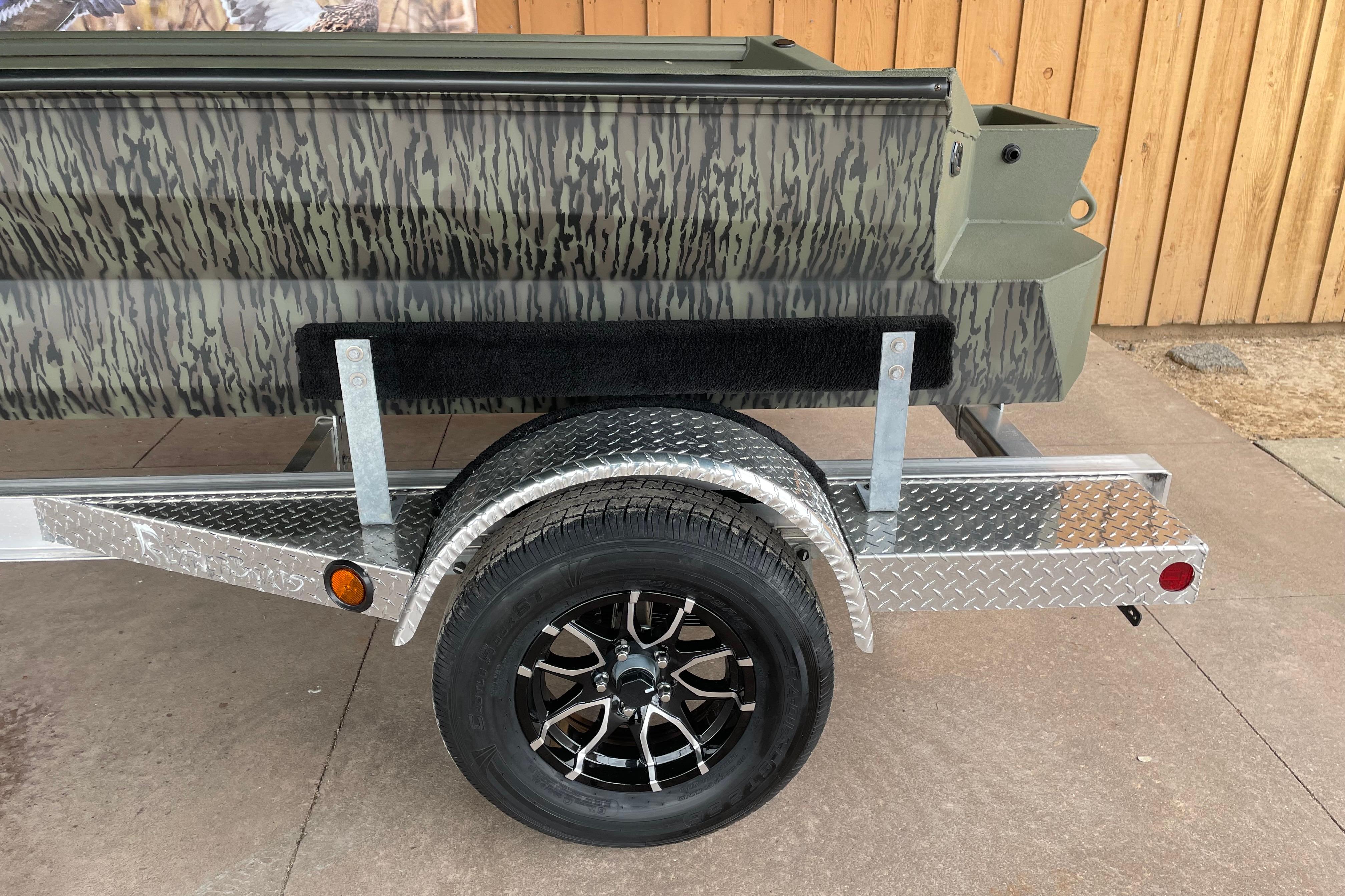 2026 Reaper Boats 753 Timber Reaper on a diamond plate trailer with camouflage design.