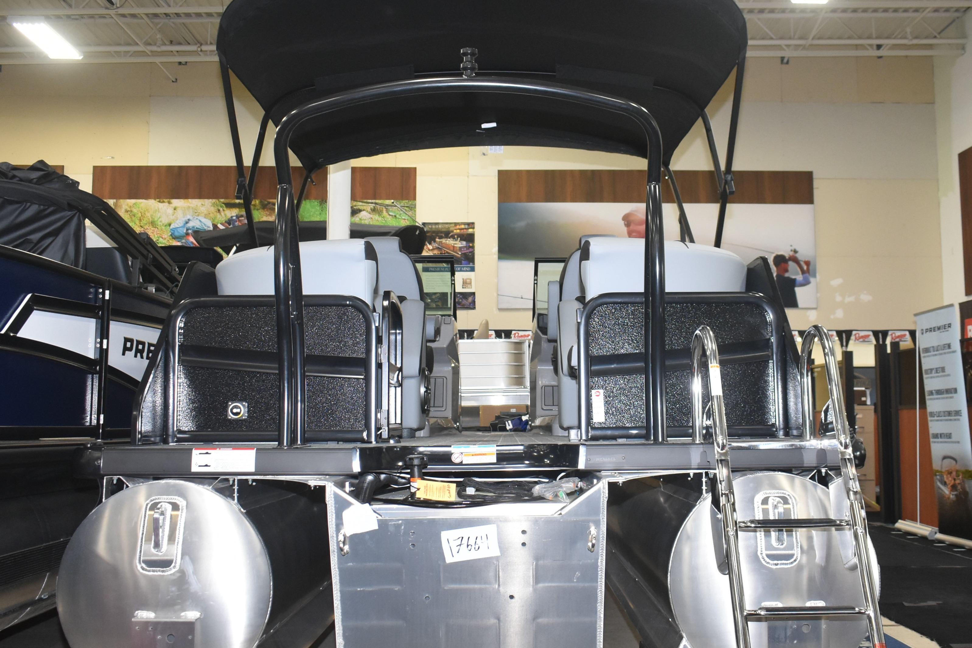 2026 Premier 250 Solaris Sport pontoon boat displayed indoors, rear view with ladder.
