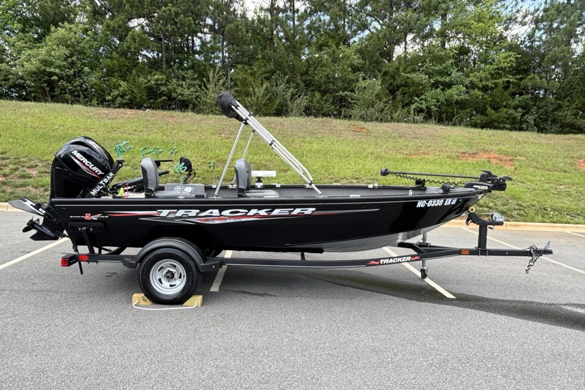 2022 Tracker Super Guide V-16 T boat on trailer, parked outdoors.