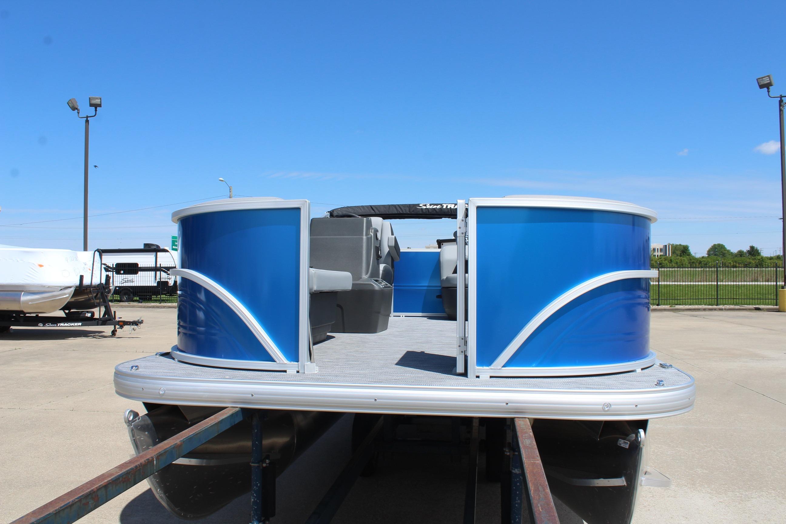 2026 Sun Tracker Party Barge 16 DLX pontoon boat with sleek blue exterior on display.